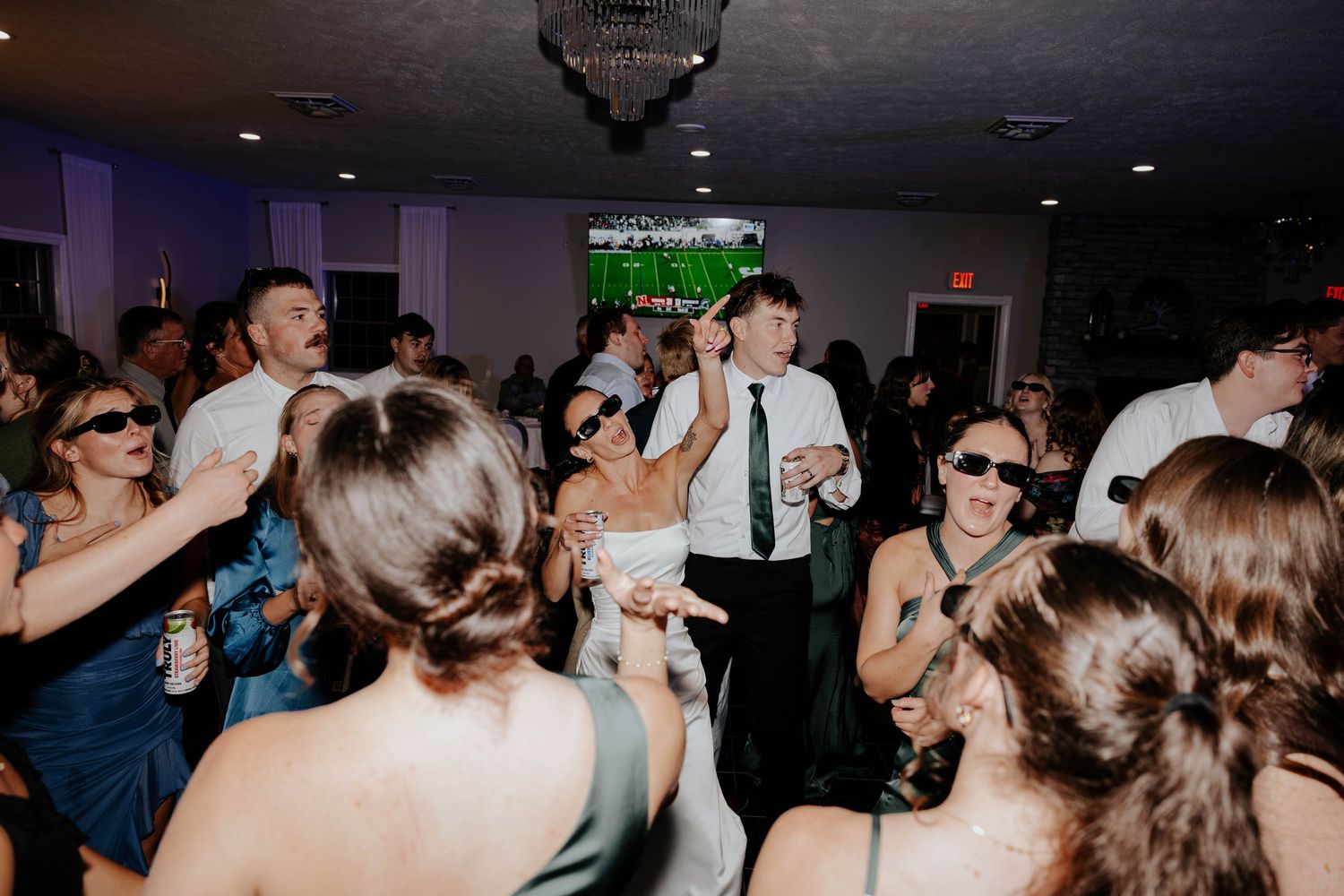 Wedding guests celebrating on a packed dance floor at Hidden Oak Manor in Indiana, captured in a candid reception photograph.