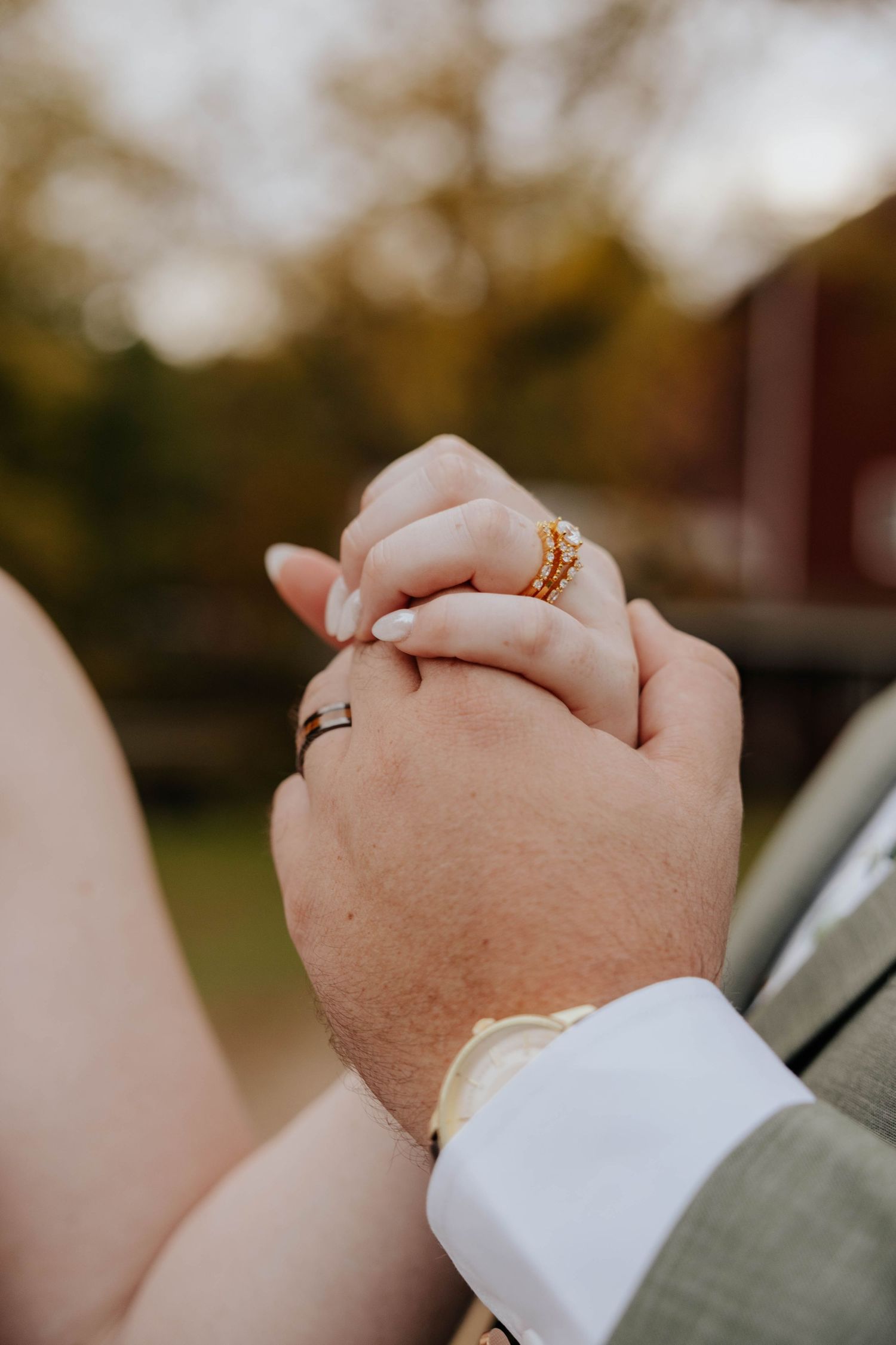 Close-up wedding photo of newlyweds holding hands, showing their wedding rings during an intimate ceremony in Middleville, Michigan.