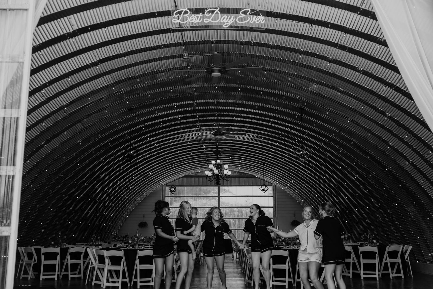 Black-and-white wide-angle photograph of the rustic barn wedding reception space at Res-Les Farms in Michigan.