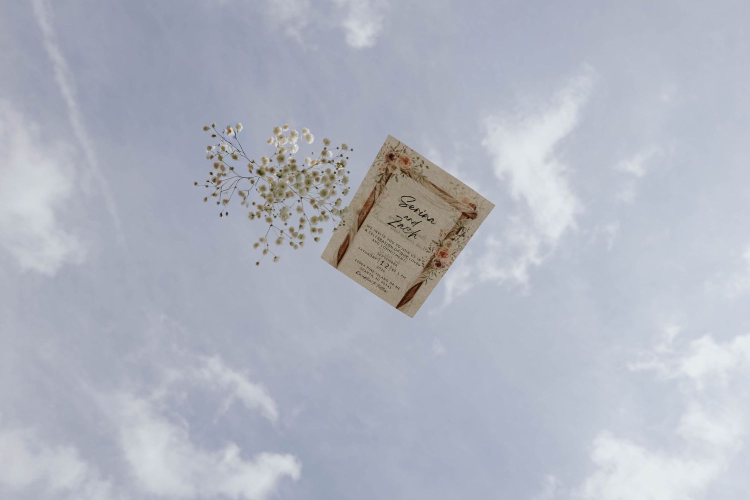 Creative wedding detail photograph of a decorative card and delicate flowers against the blue sky at a wedding in Sparta, Michigan.