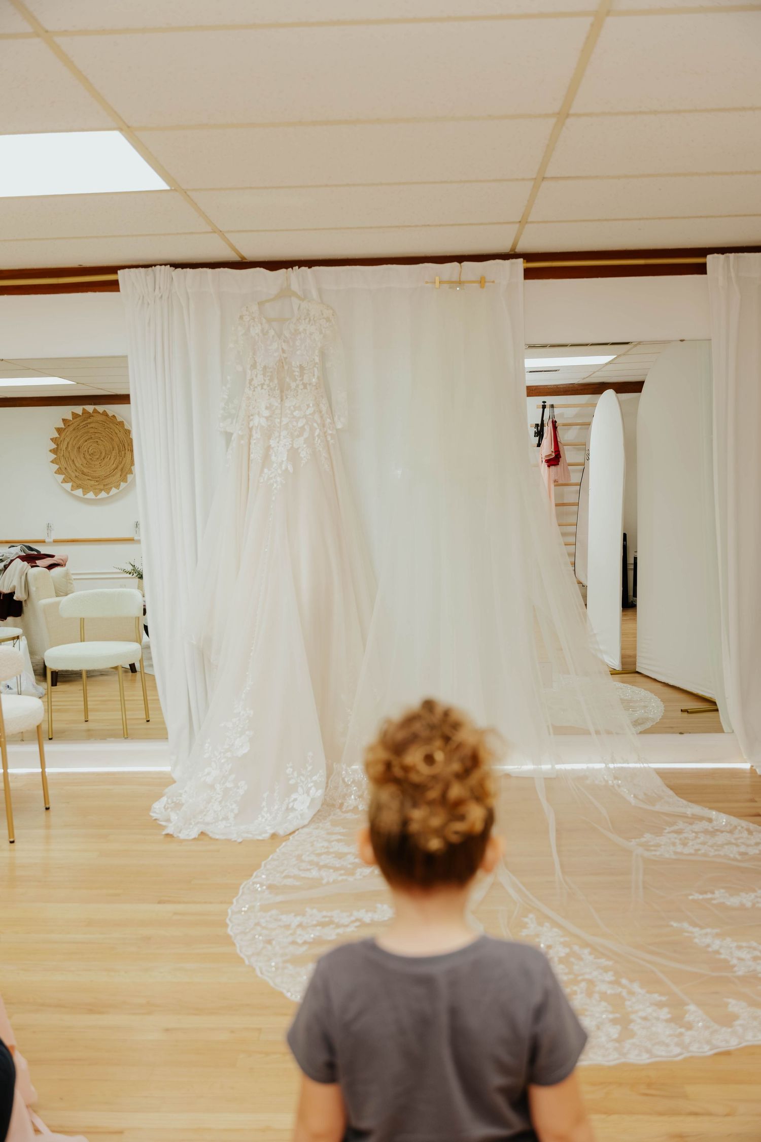 White wedding dress hanging on display at Bloom Wellness & Beauty in Battle Creek, Michigan, before the bride gets ready.