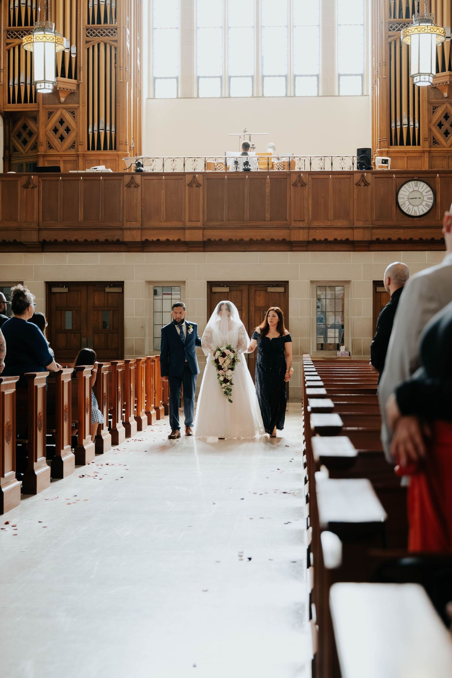 Bride walking down the aisle during a traditional Catholic church wedding ceremony in Kalamazoo, Michigan.