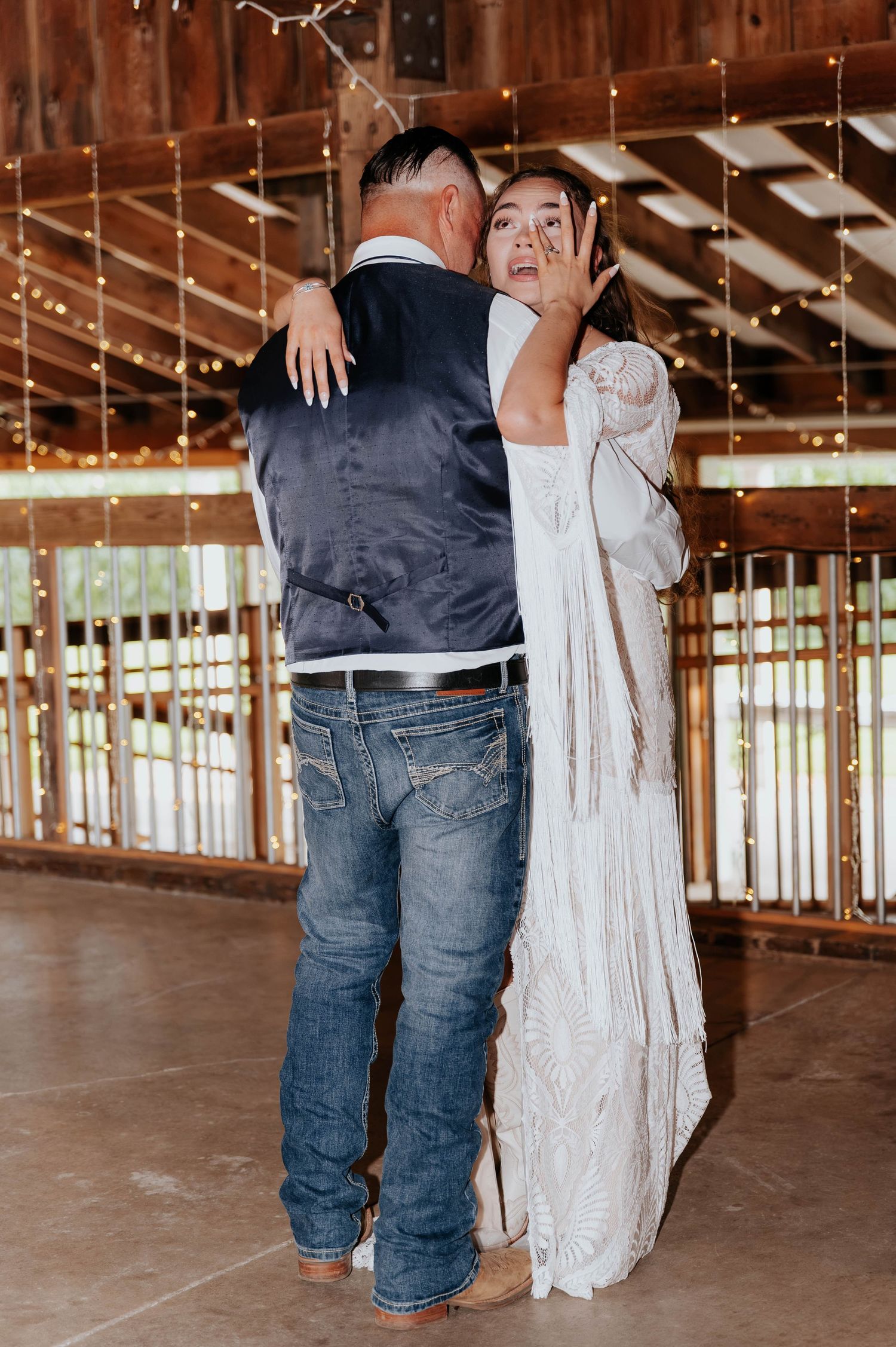 Father and daughter share a heartfelt dance inside the rustic barn at The Gather wedding venue in Allegan, Michigan.