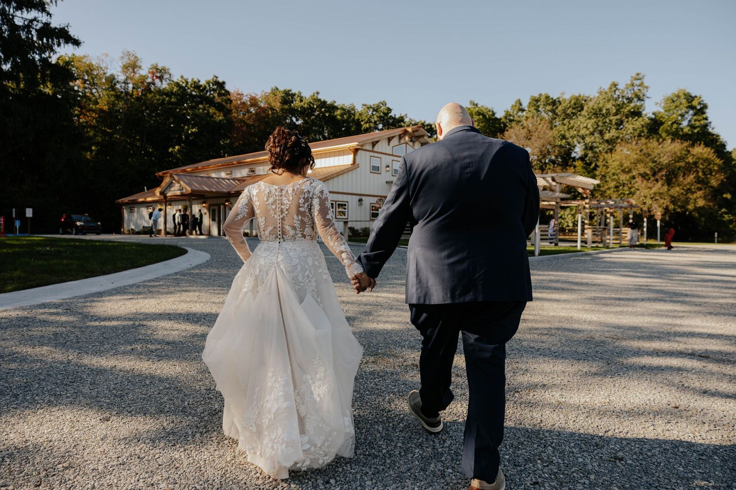 Bride and groom walking together outdoors at Elm Valley Farm in Galesburg, Michigan, during their wedding day.