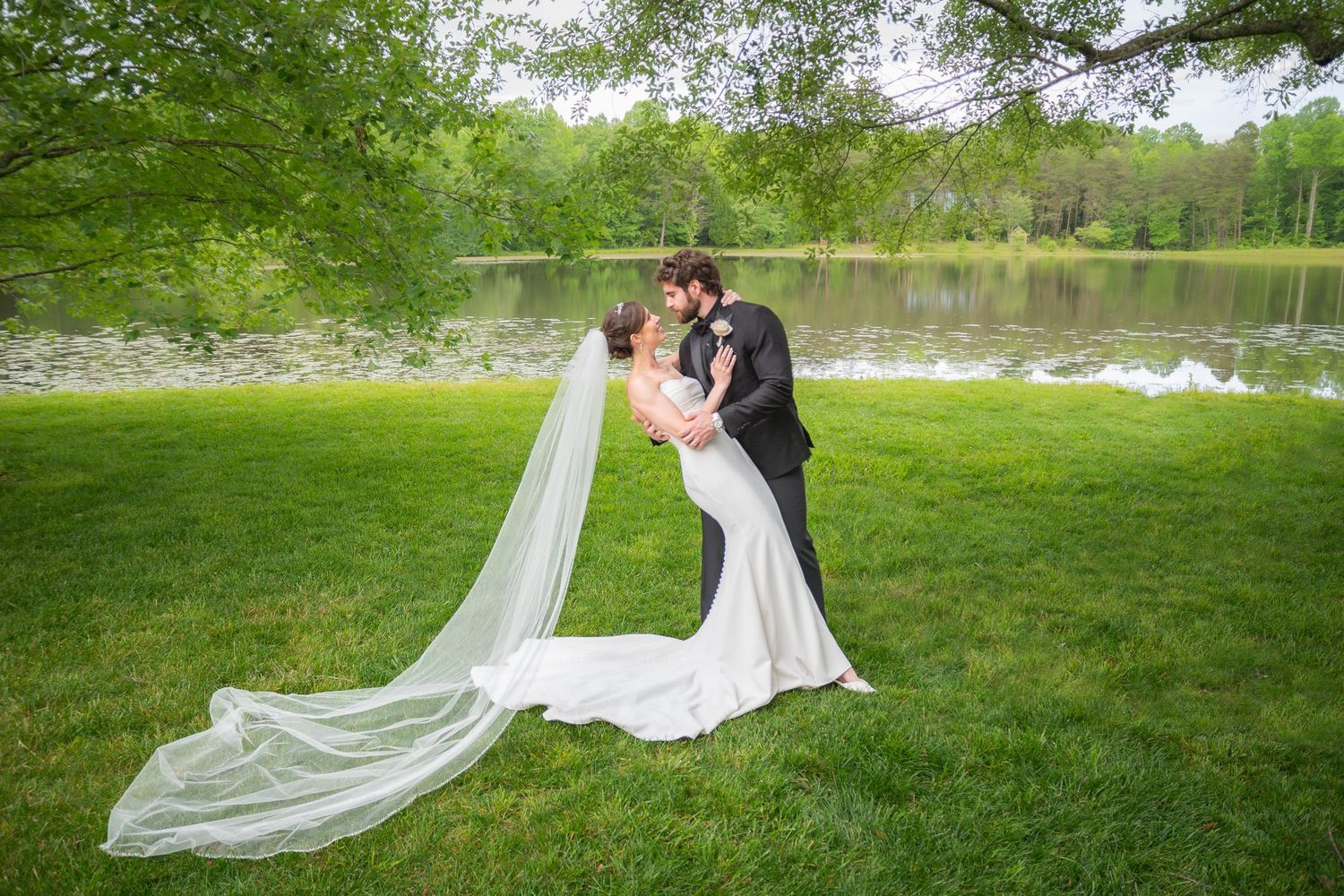 Bride and groom standing on a green lawn