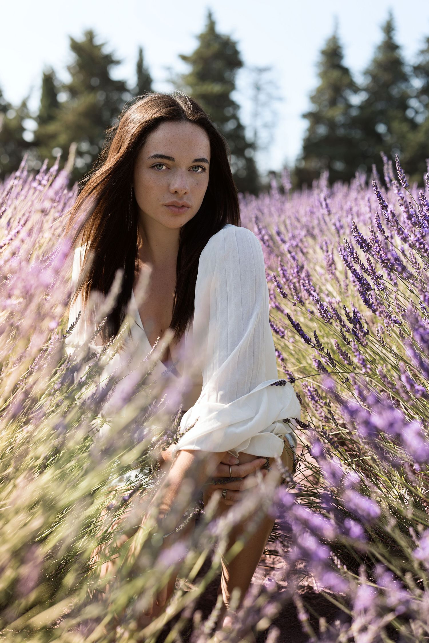 Portrait de femme de blanc vêtue, dans les champs de lavande de Provence lors d'une séance photo lifestyle en extérieur