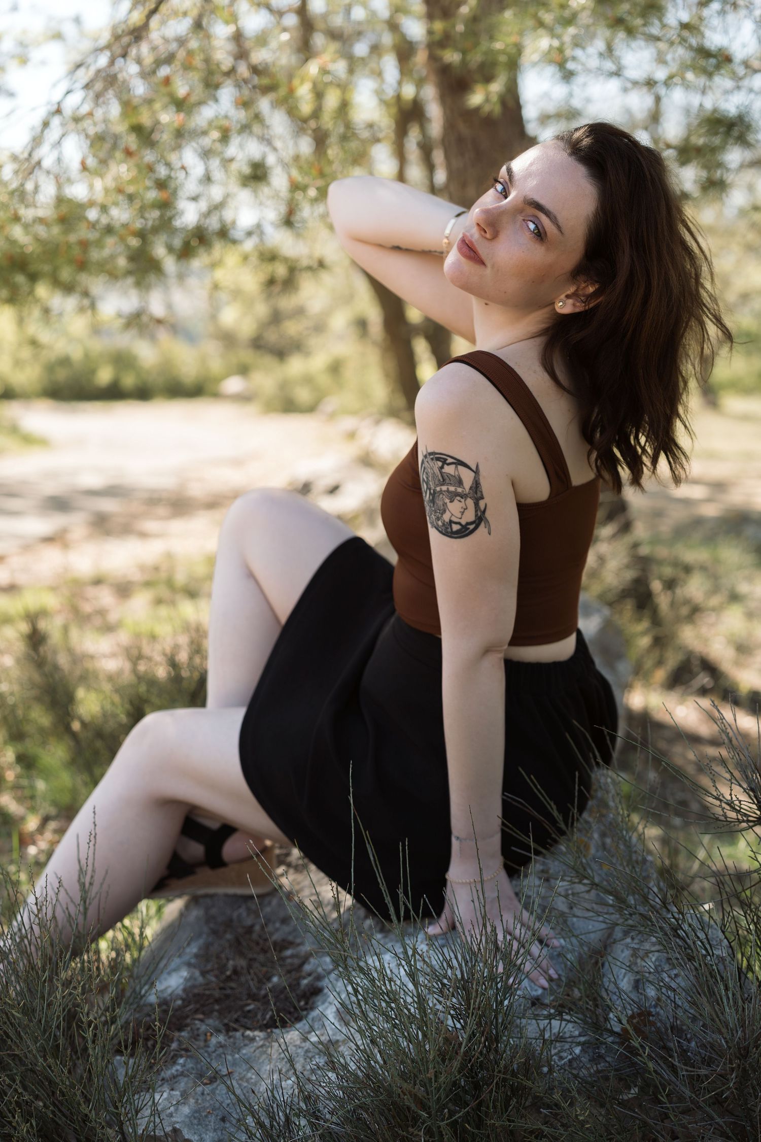 Portrait d'une femme assise sur un rocher à l'ombre pour une séance photo lifestyle à Avignon