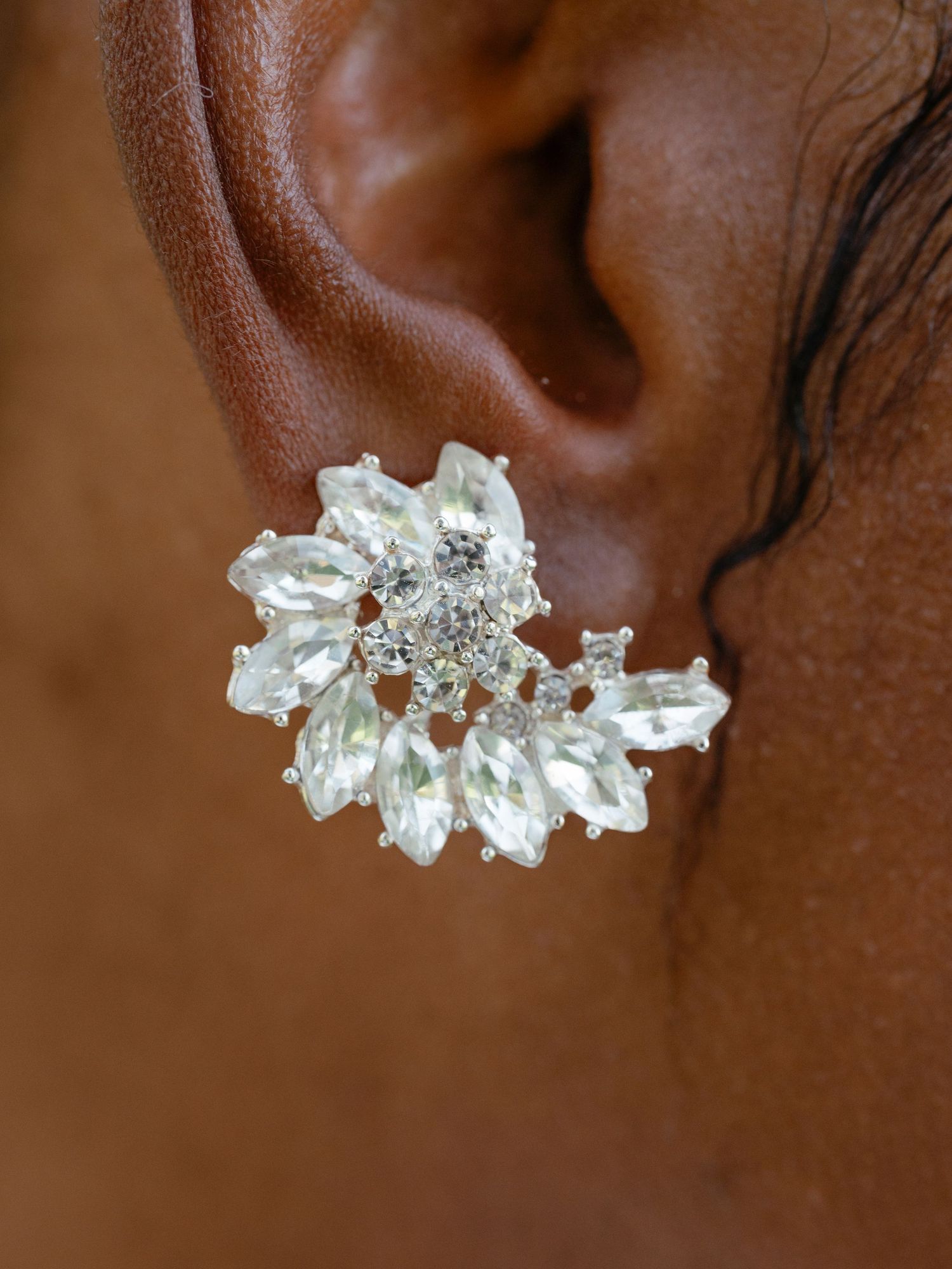 Close-up of a sparkling crystal cluster bridal earring worn by a Black bride.