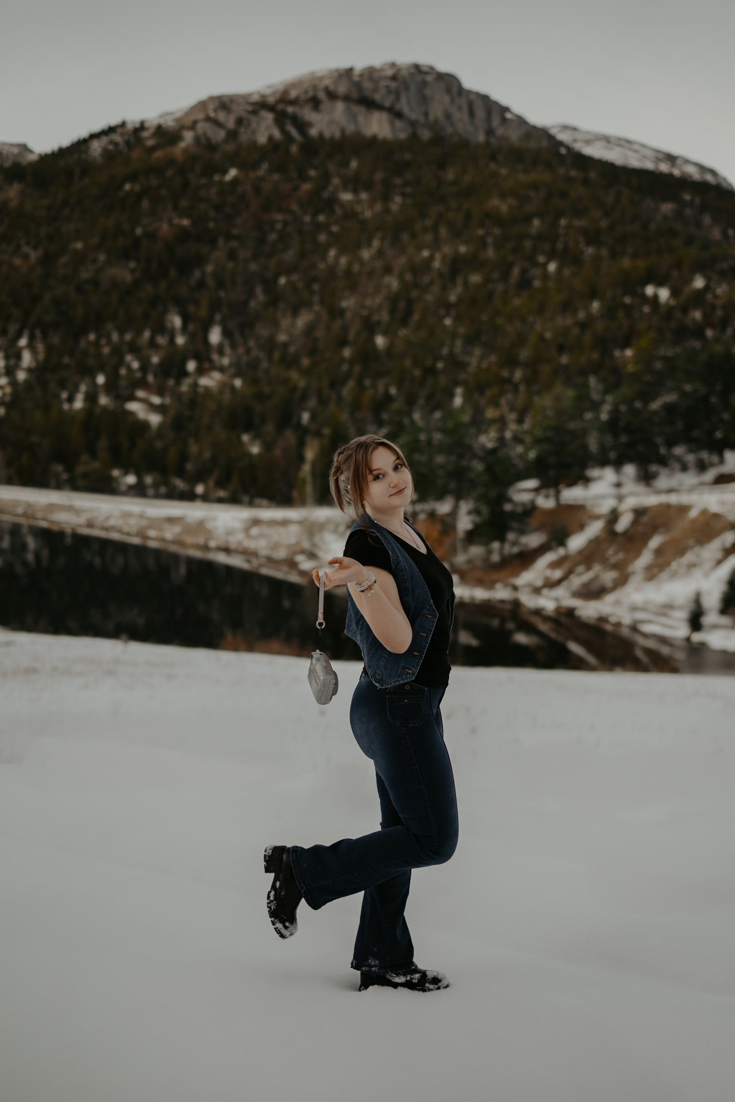 A Colorado elopement photographer captures images in a snowy mountain setting with her polaroid camera at Lake Isabel.