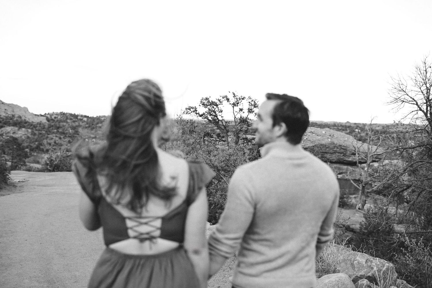 Black and white, cinematic, moody photo of a couple sharing an intimate moment against a mountain backdrop at Garden of the Gods.