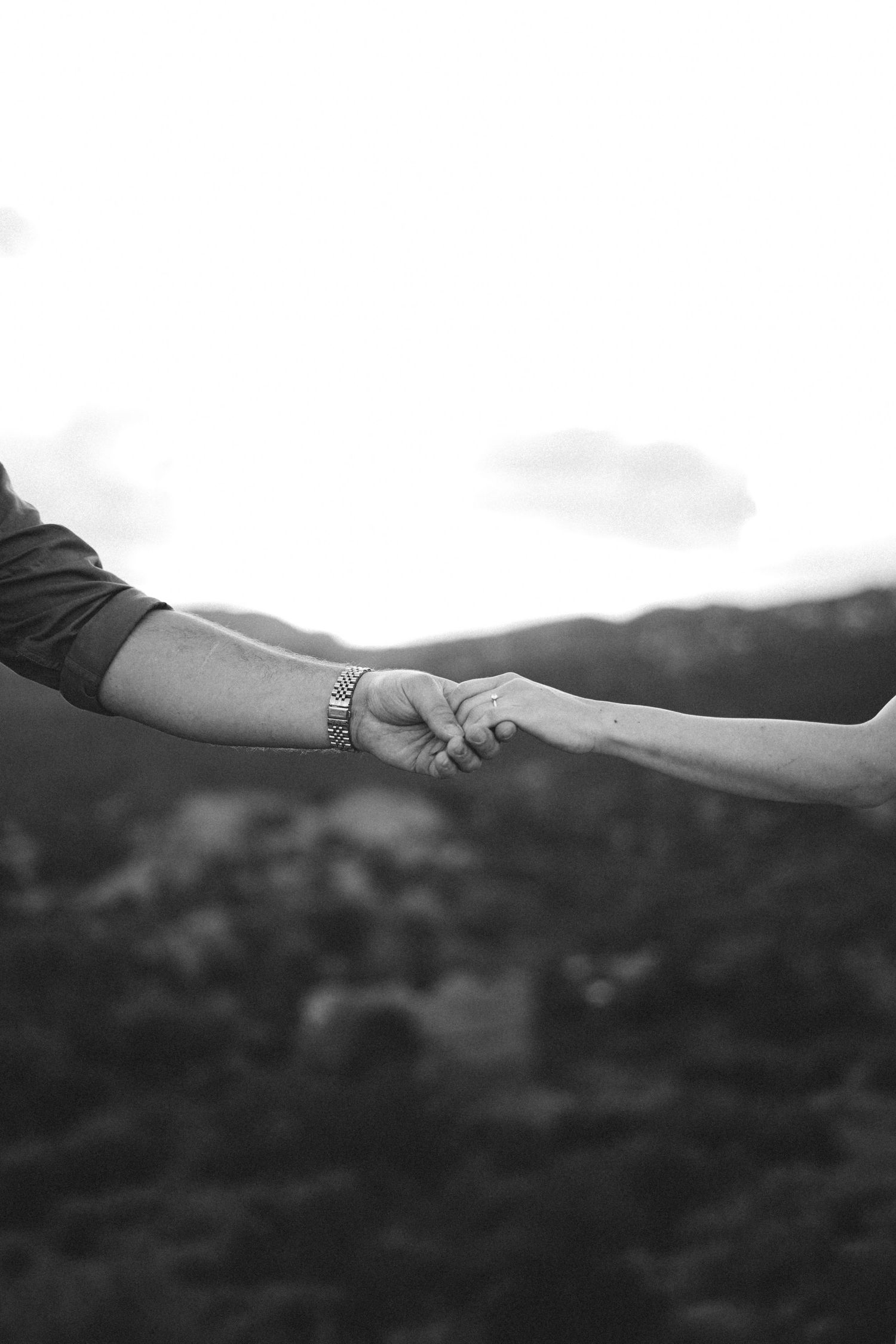 Scenic mountain landscape with loving hands reaching towards each other in black and white at Garden of the Gods.