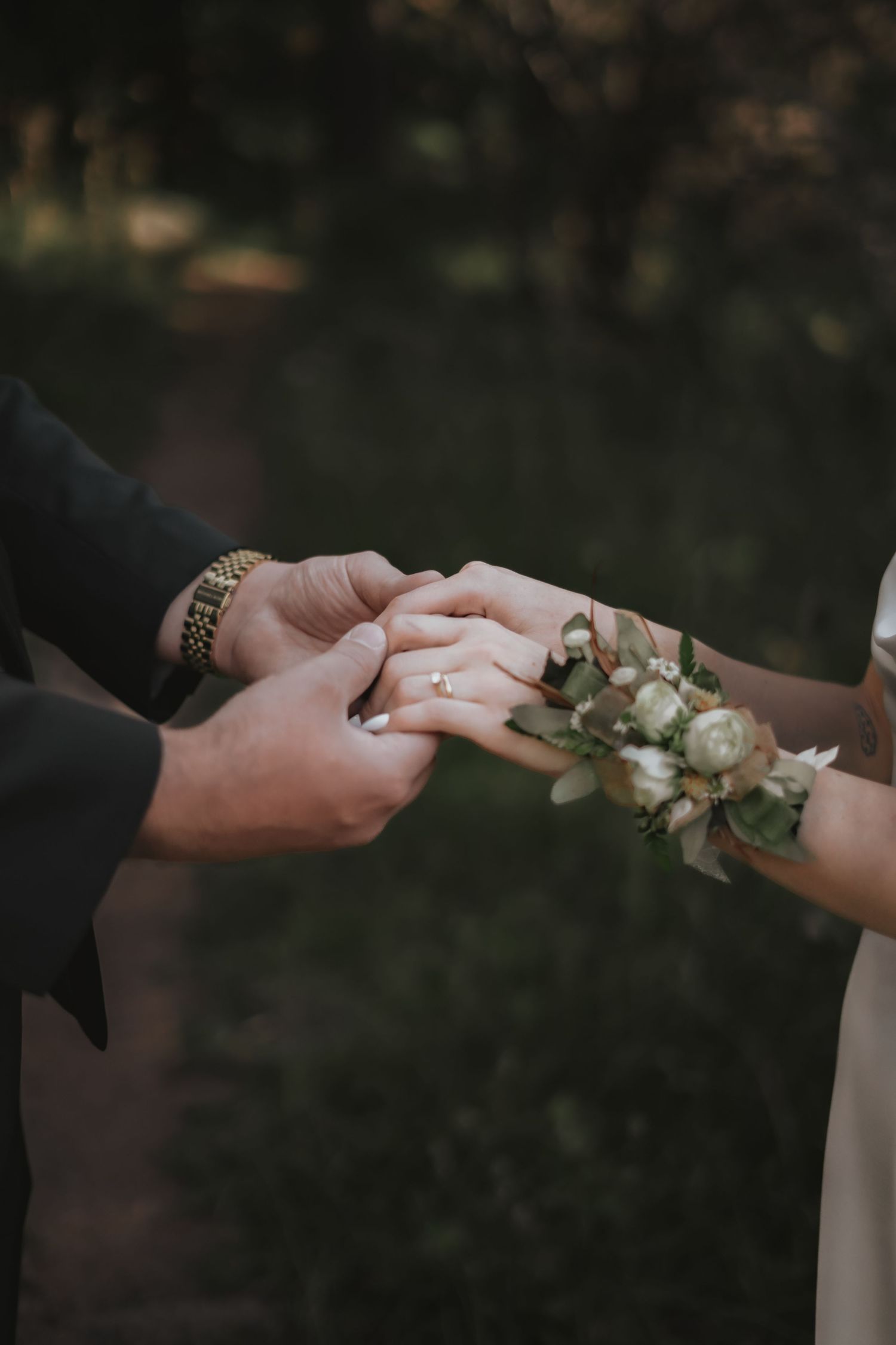 Close-up of hands at an intimate forest wedding ceremony in Pueblo Mountain Park.