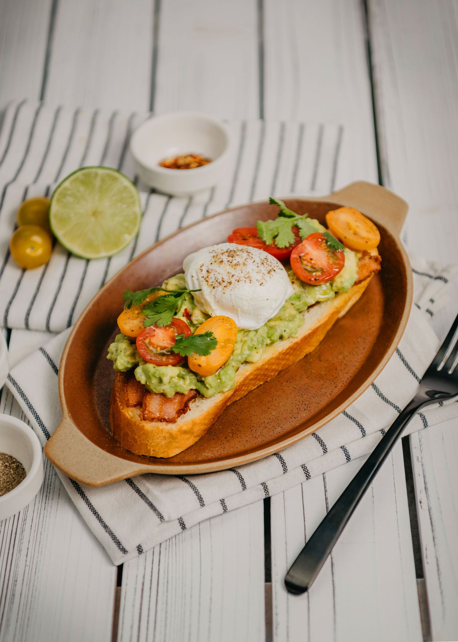 Plated avocado toast with poached egg and additional garnishes, Calgary food photographer