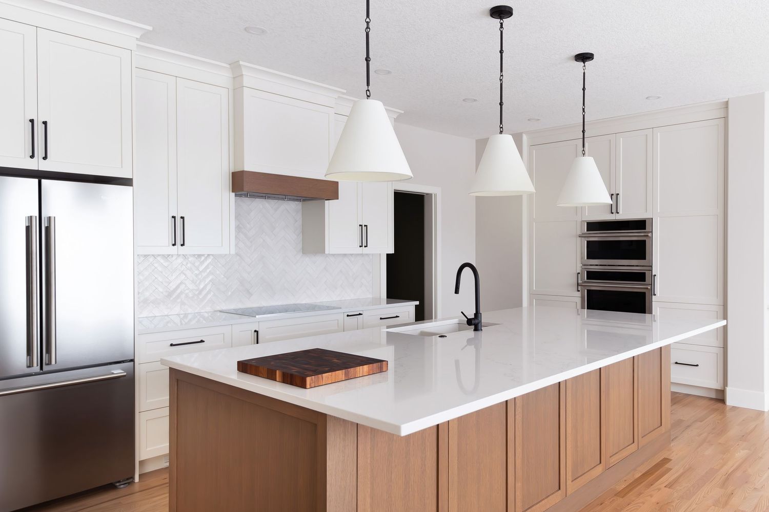 Modern white kitchen with quartz countertops, and wooden accents Calgary interior photographer