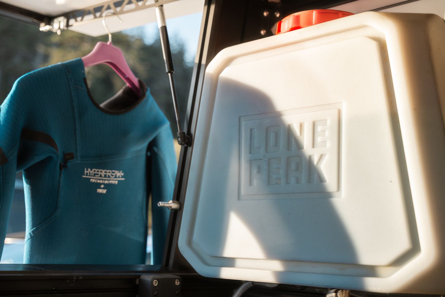 Interior view of a rooftop tent showing storage compartments and 10 gallon water tank.