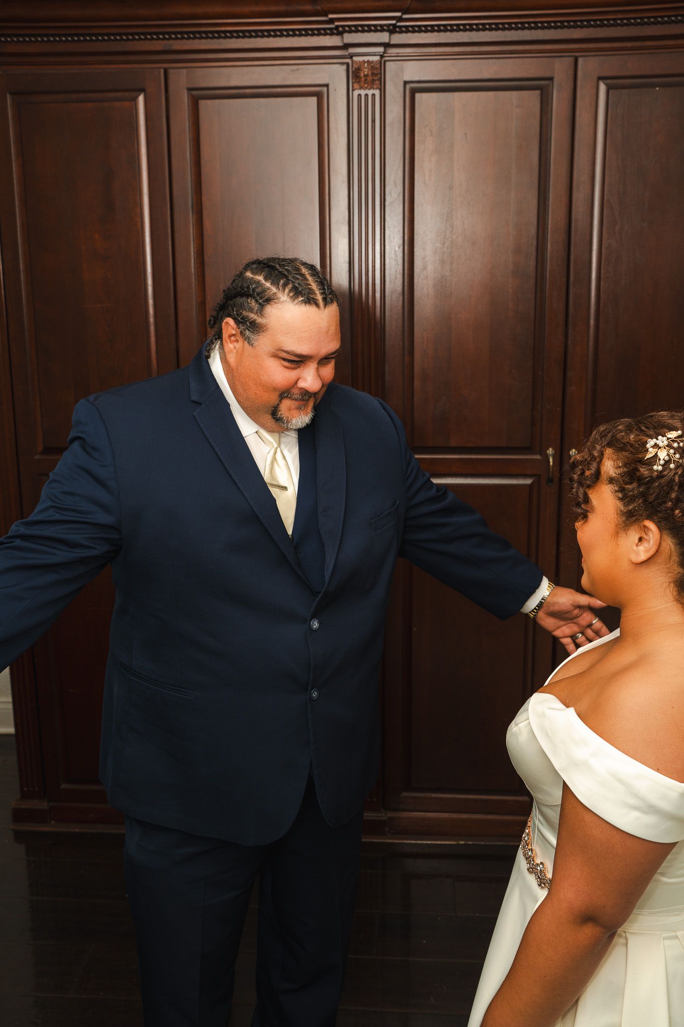 Father emotional during first look with bride in white off-shoulder gown before wedding ceremony.
