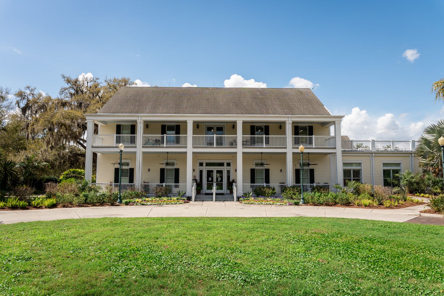 Grand two-story Southern-style wedding venue with white columns and manicured green lawn.