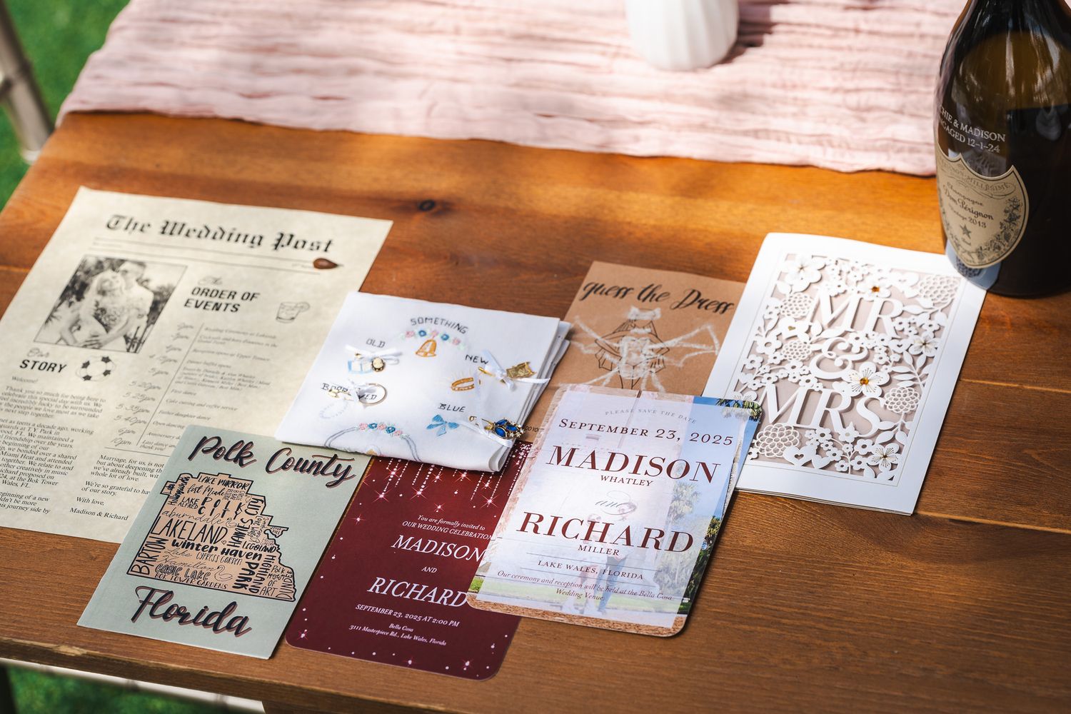 Elegant wedding stationery suite featuring invitations, programs, and details cards spread on a wooden table.