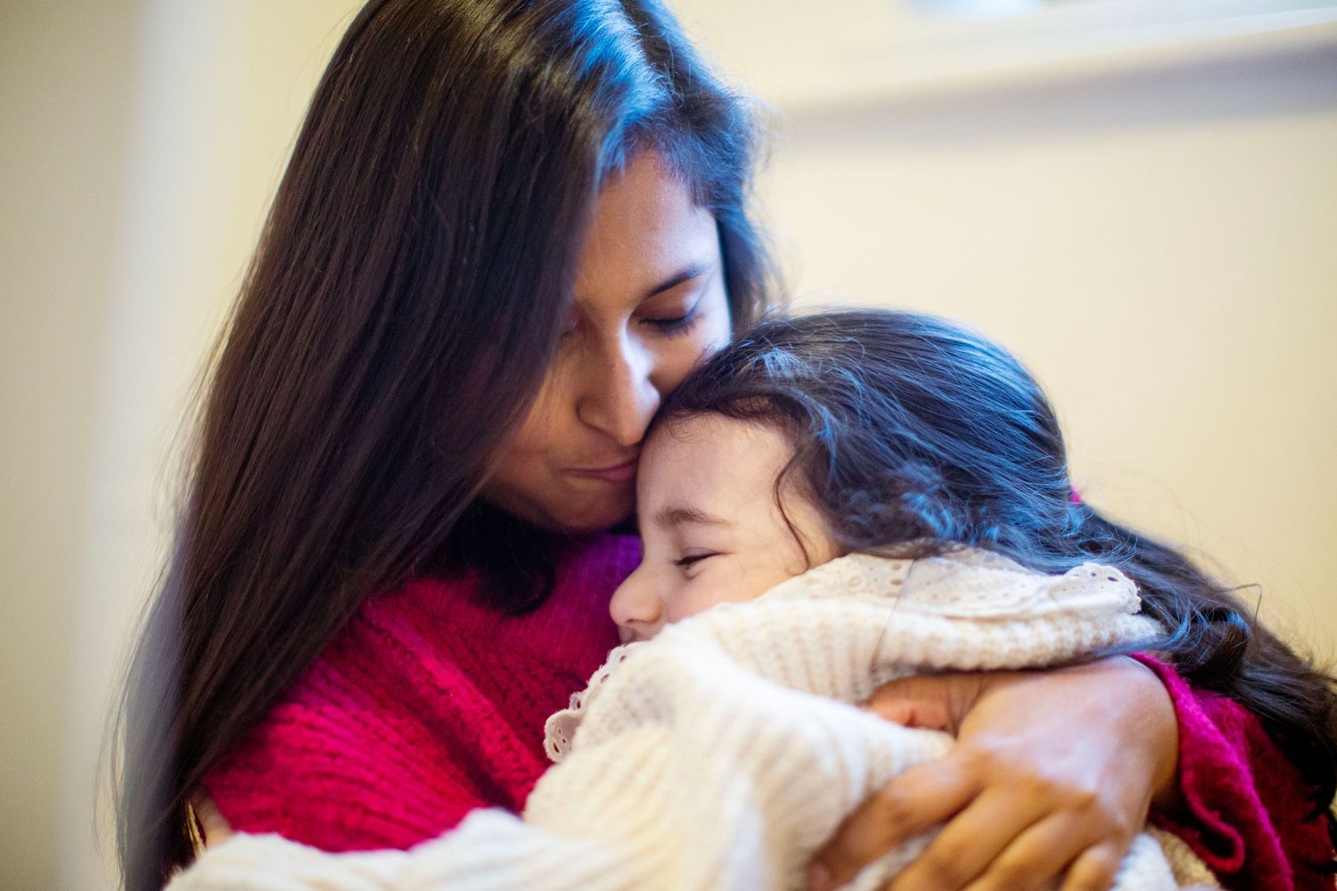 A mother-daughter cuddle during a photo session. The Mother's Eye - candid documentary-stele motherhood photography in Bermondsey, London.