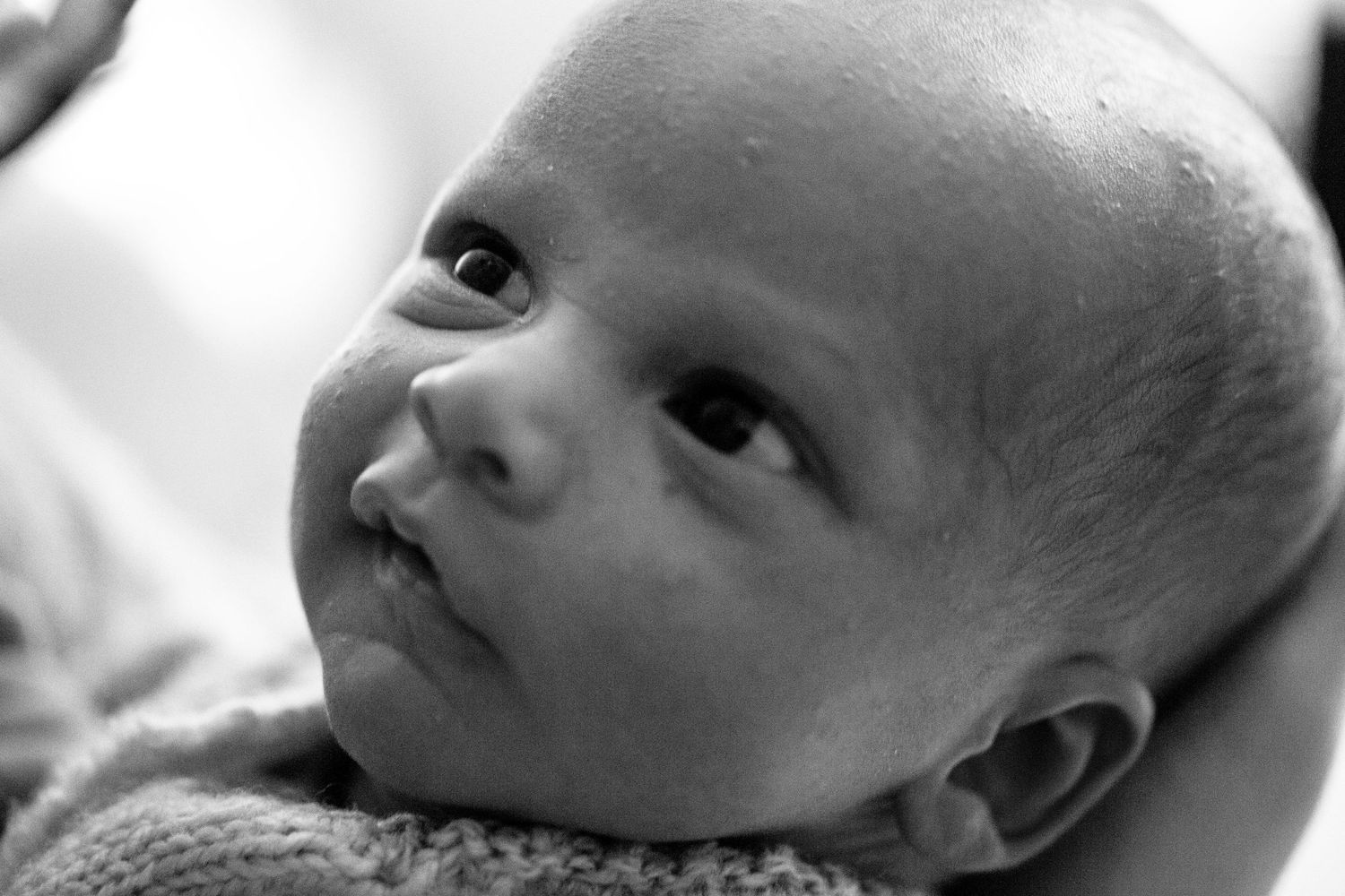 Newborn looking and smiling. Poetic documentary childhood, newborn and family photography by The Mother's Eye, Peckham, South East London.