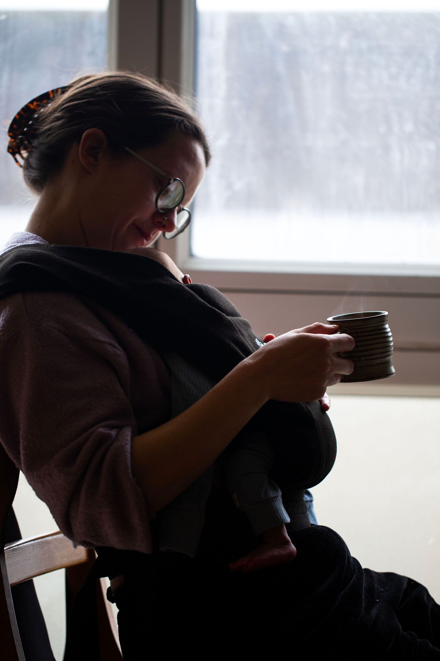 Relaxed morning coffee, mum and her newborn in a sling. Candid matrescence, motherhood and postpartum photography in Crystal Palace, London.