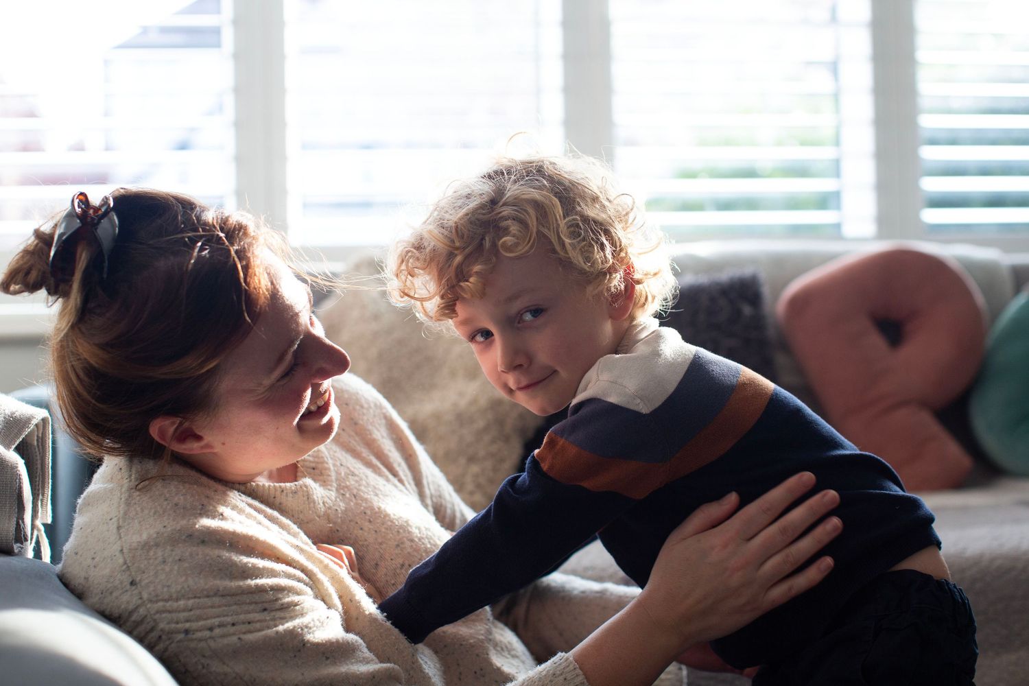A mother-son cuddle during a photo session. The Mother's Eye - candid documentary-stele motherhood photography in Bermondsey, South London.