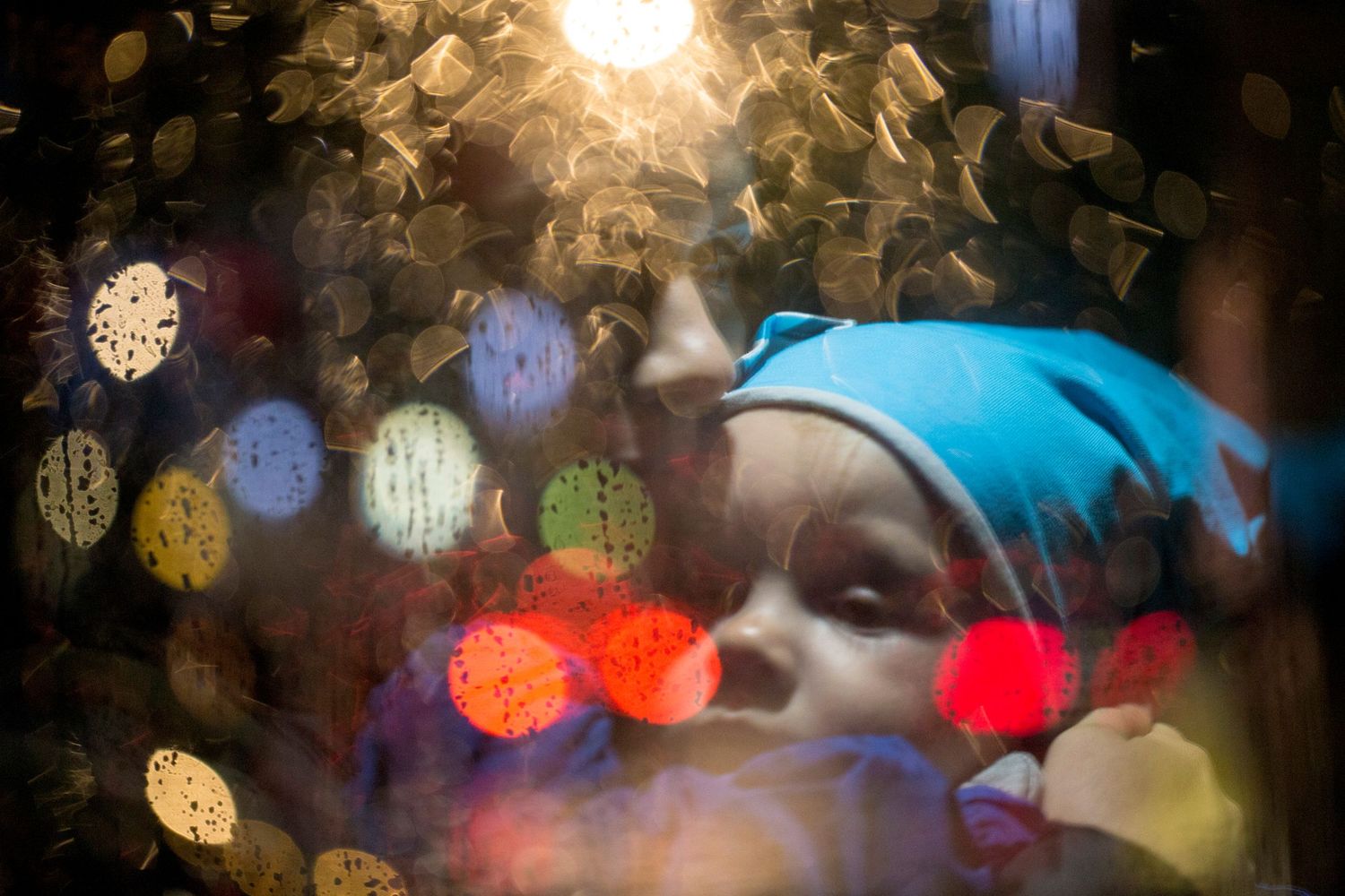 Mum holds toddler surrounded by lights. Playful and candid childhood and family photography by The Mother's Eye, Peckham, South East London.