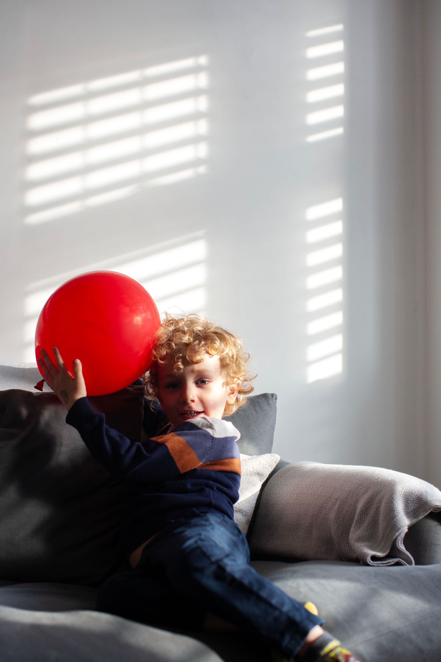 A boy with a red balloon, a candid and fun documentary family and childhood photoshoot by The Mother's Eye in Peckham, South East London.