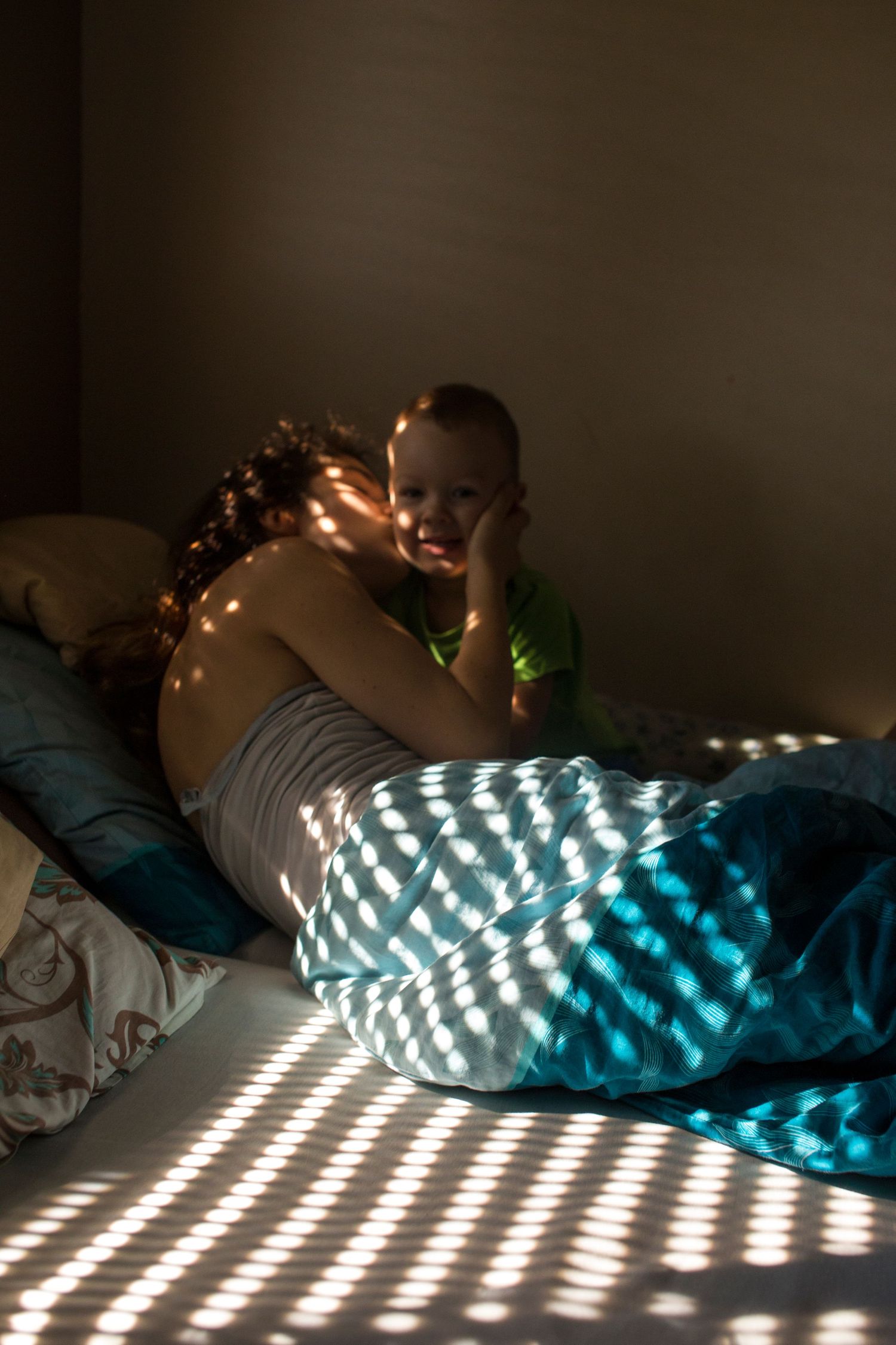 Mum and toddler in beautiful light on bed. Postpartum and motherhood photography by The Mother's Eye in Crystal Palace, South East London.