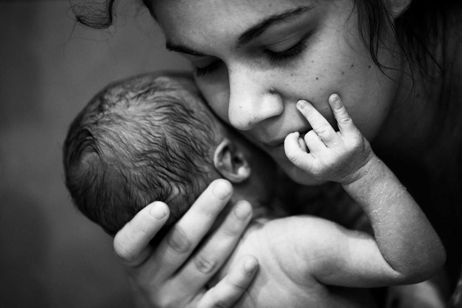 Close-up of a mum cradling her newborn. Motherhood, newborn and birth photography by The Mother's Eye, East Dulwich, South East London.