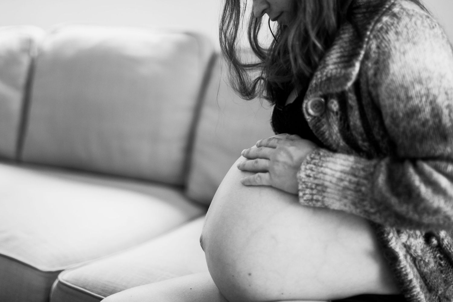 Pregnant woman on a sofa at home. Poetic maternity and pregnancy photography by The Mother's Eye in Bermondsey, South East London.