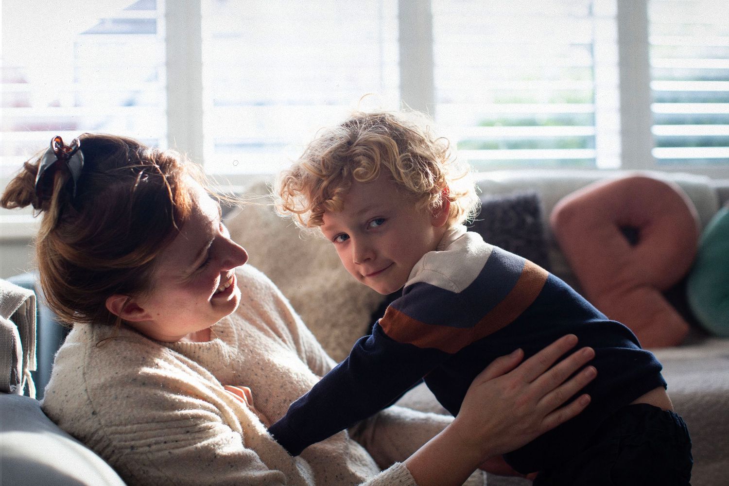 A mother-son cuddle during a photo session. The Mother's Eye - candid documentary-stele motherhood photography in Bermondsey, South London.