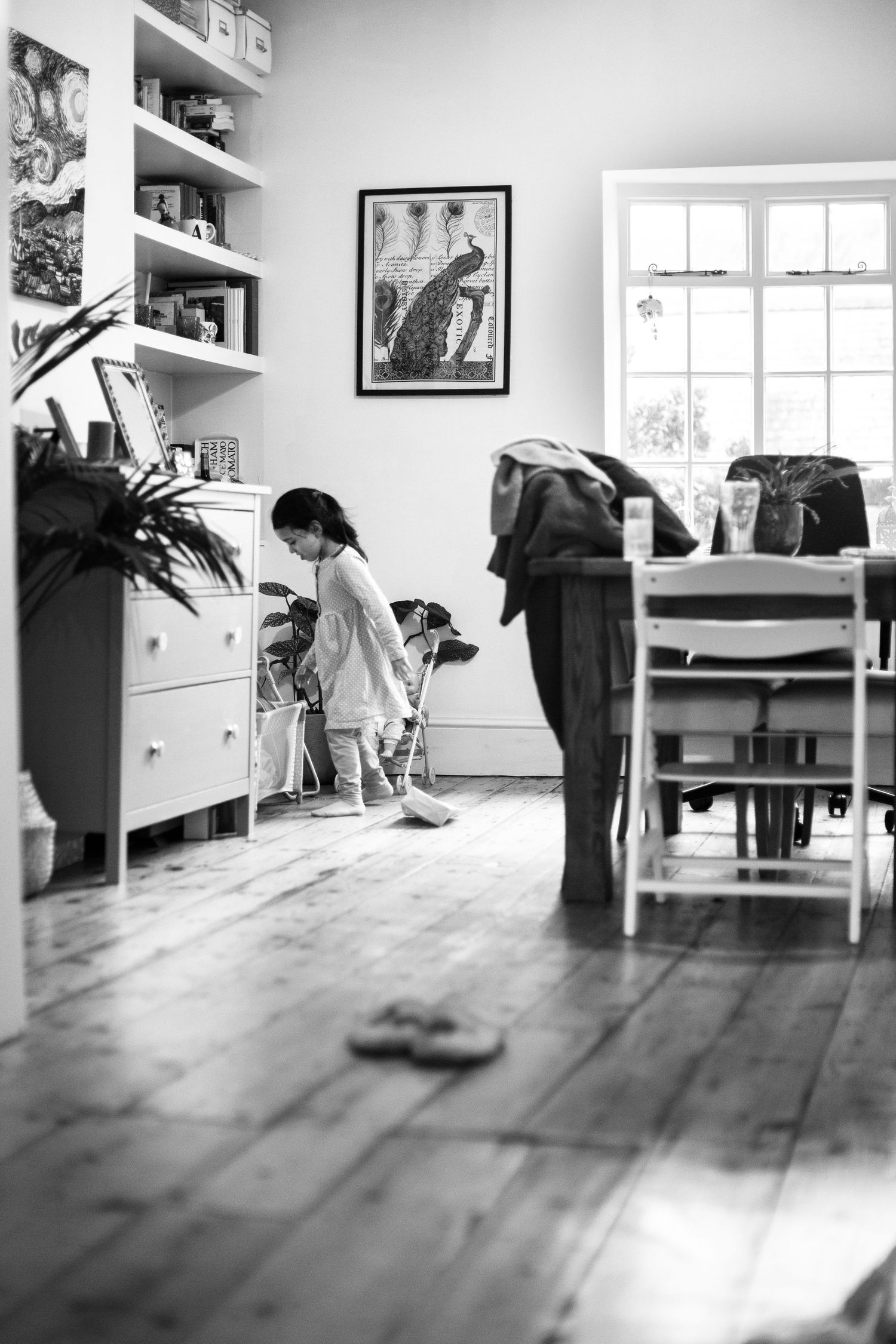 Wide shot of a toddler girl running around the house. Lifestyle childhood and family photographer The Mother's Eye in Beckenham, London.