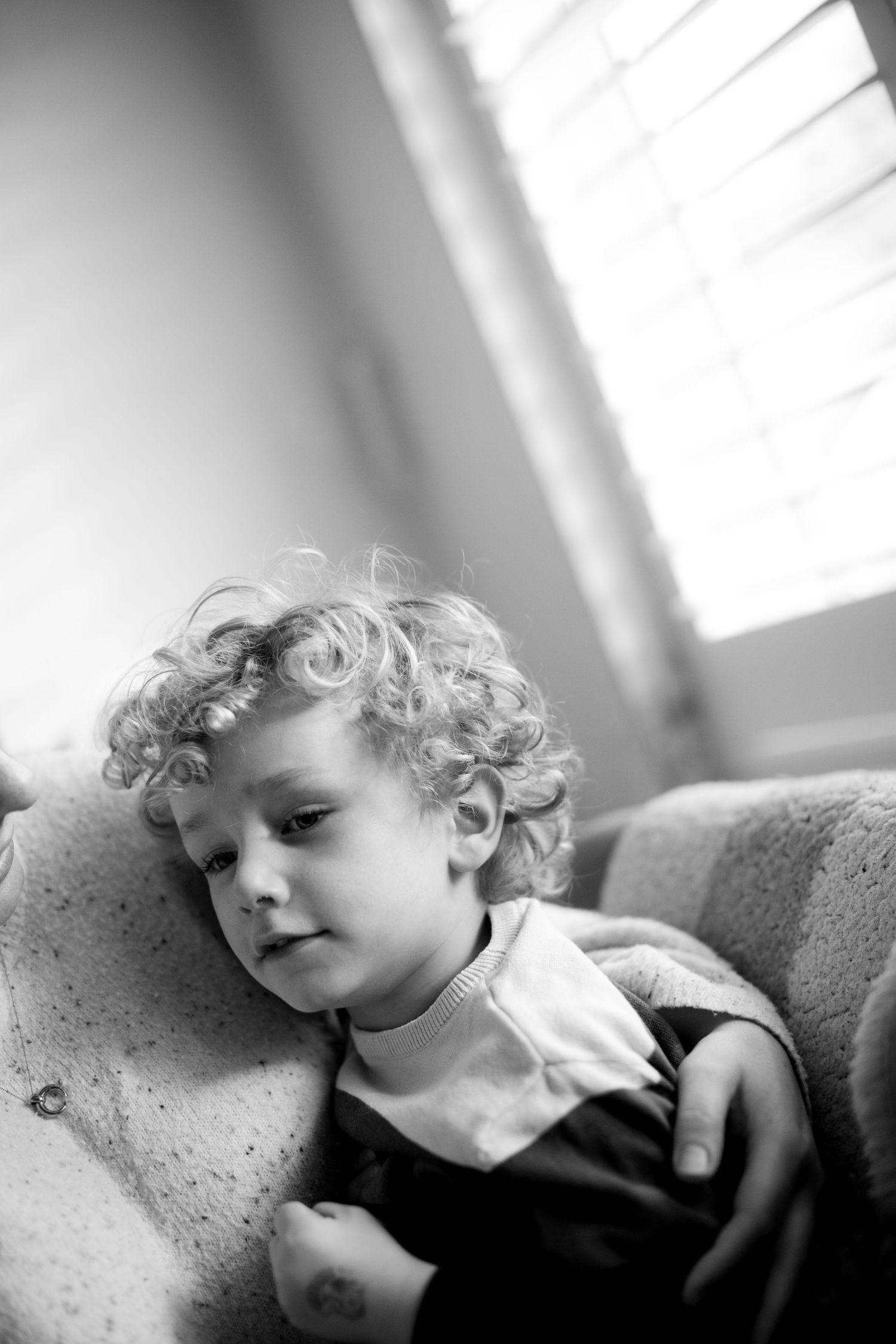 A mother-son cuddle during a photo session. The Mother's Eye - candid documentary-stele motherhood photography in Beckenham, London.