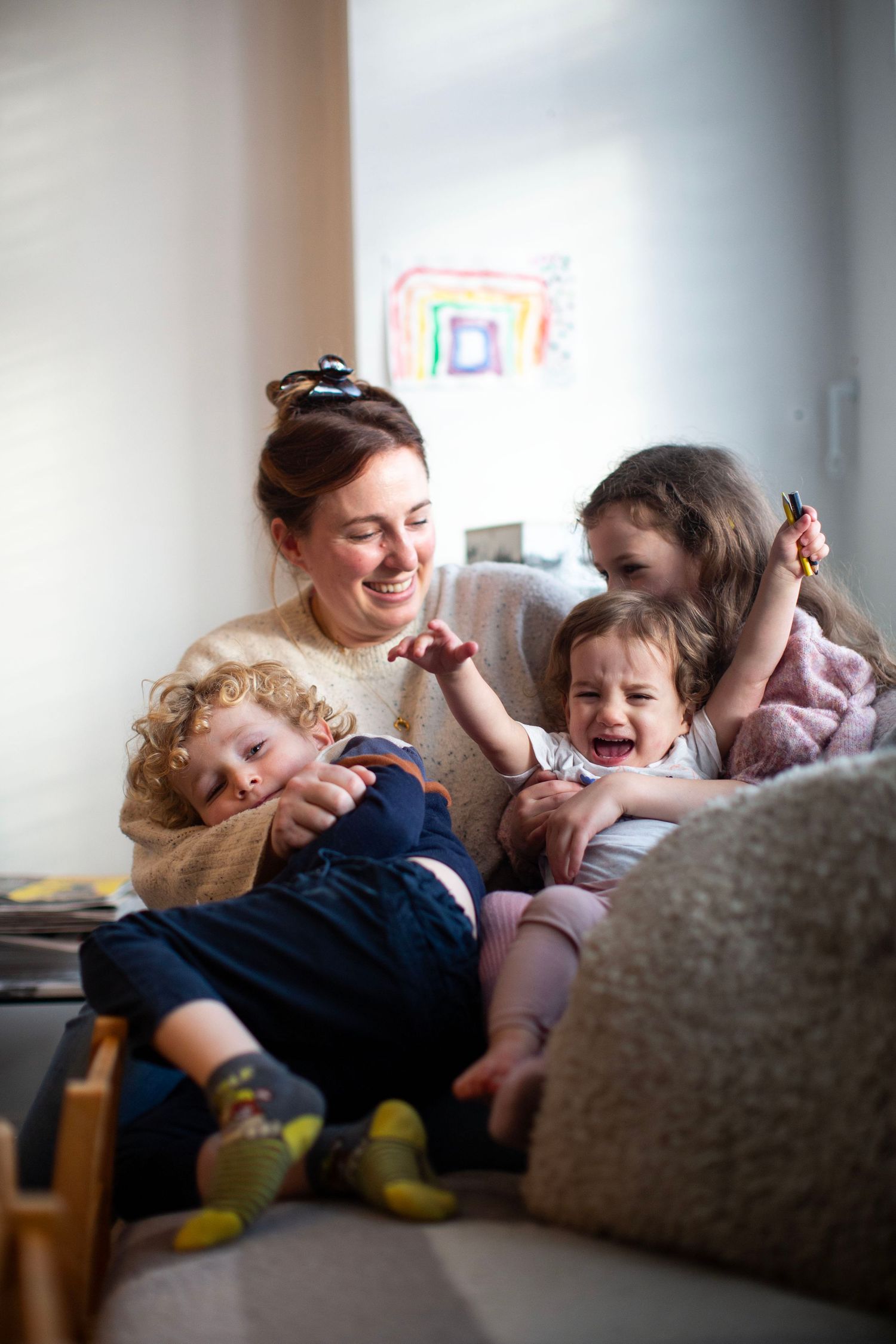 Mum cuddles with her 3 children. The Mother's Eye - candid documentary-stele motherhood photography in Beckenham, South East London.