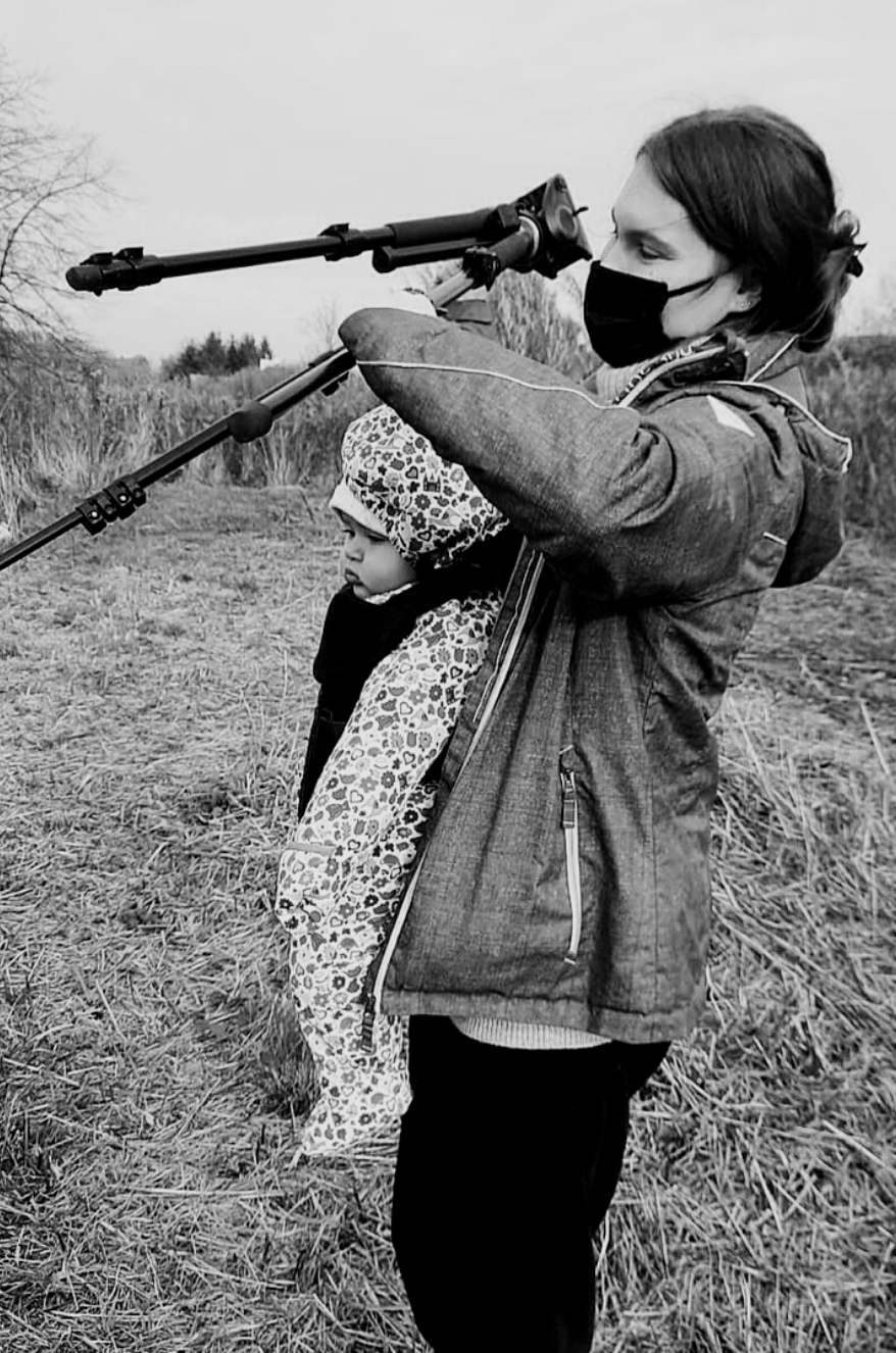 The Mother's Eye founder Gloria Kurnik with her baby in a sling photographing. Documentary maternity session in Dulwich, South East London.