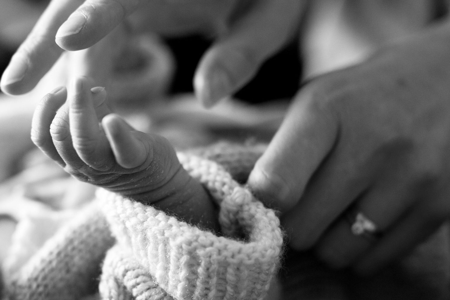 Mum touching newborn's hand. Documentary childhood, newborn and family photography by The Mother's Eye, Lewisham, South East London.