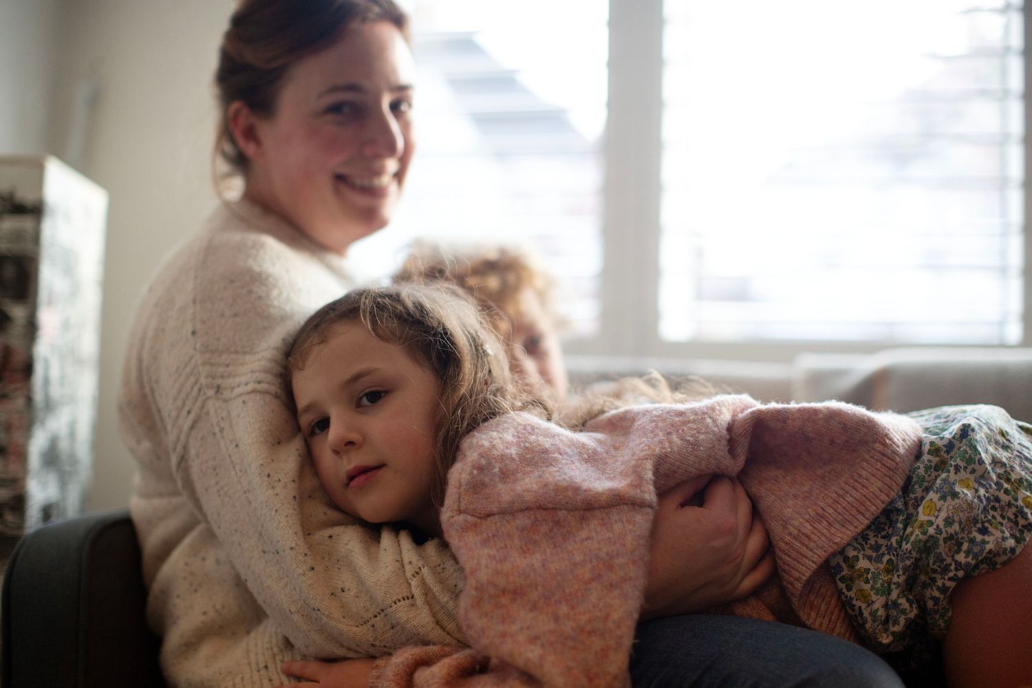 Mum and daughter cuddle at a photo session. The Mother's Eye - candid documentary-stele motherhood photography in East Dulwich, London.
