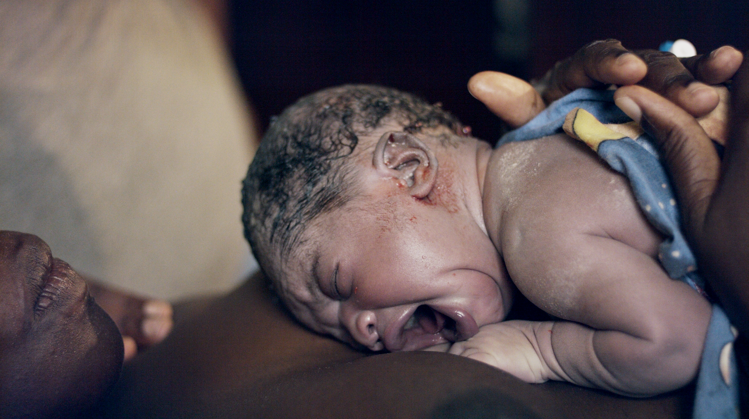 A few seconds old baby laying on her mother's chest having skin to skin. The Mother's Eye home birth photography in Southwark, London.