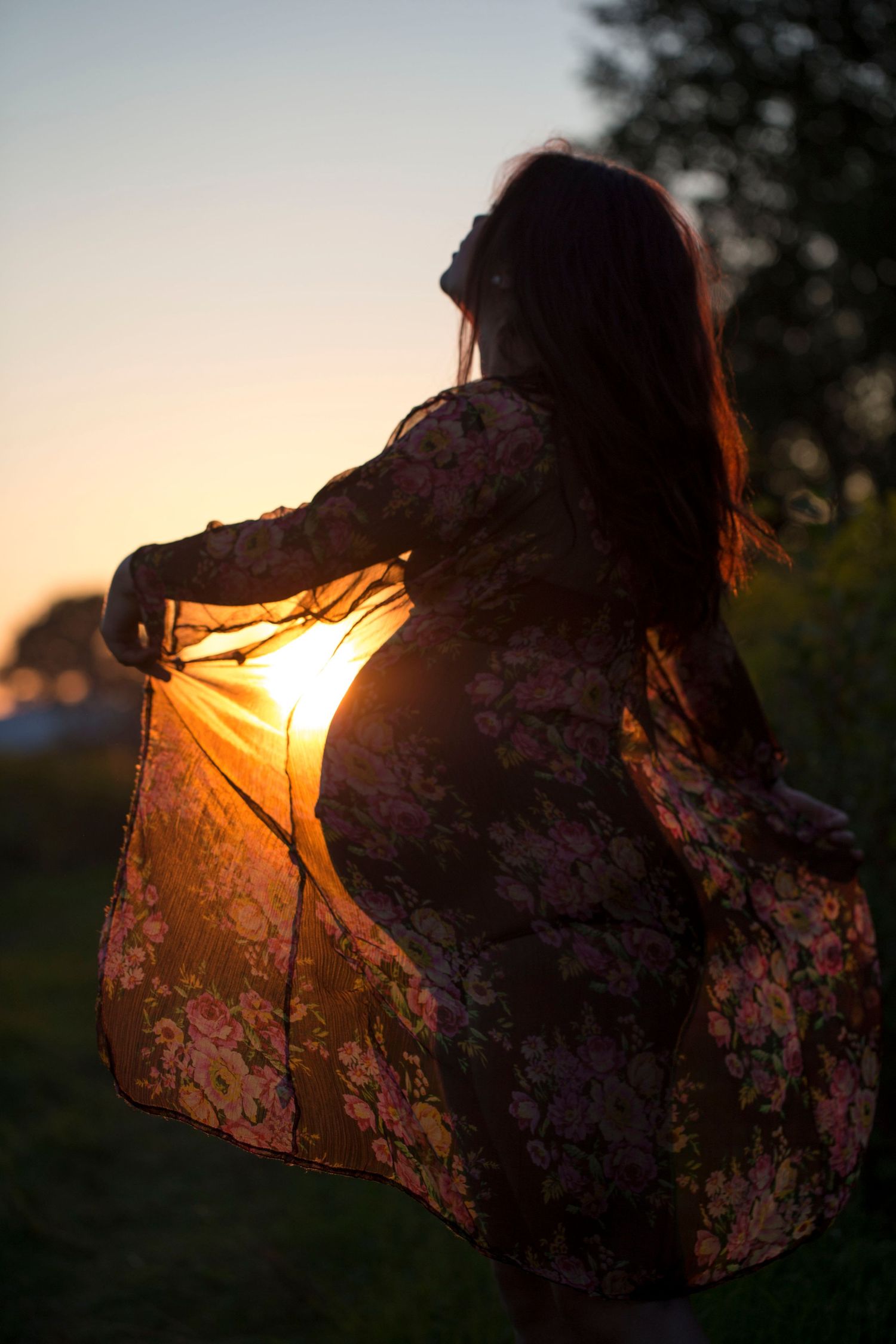 Pregnant woman in a field at sunset. Poetic maternity and pregnancy photography by The Mother's Eye in Beckenham, South East London.