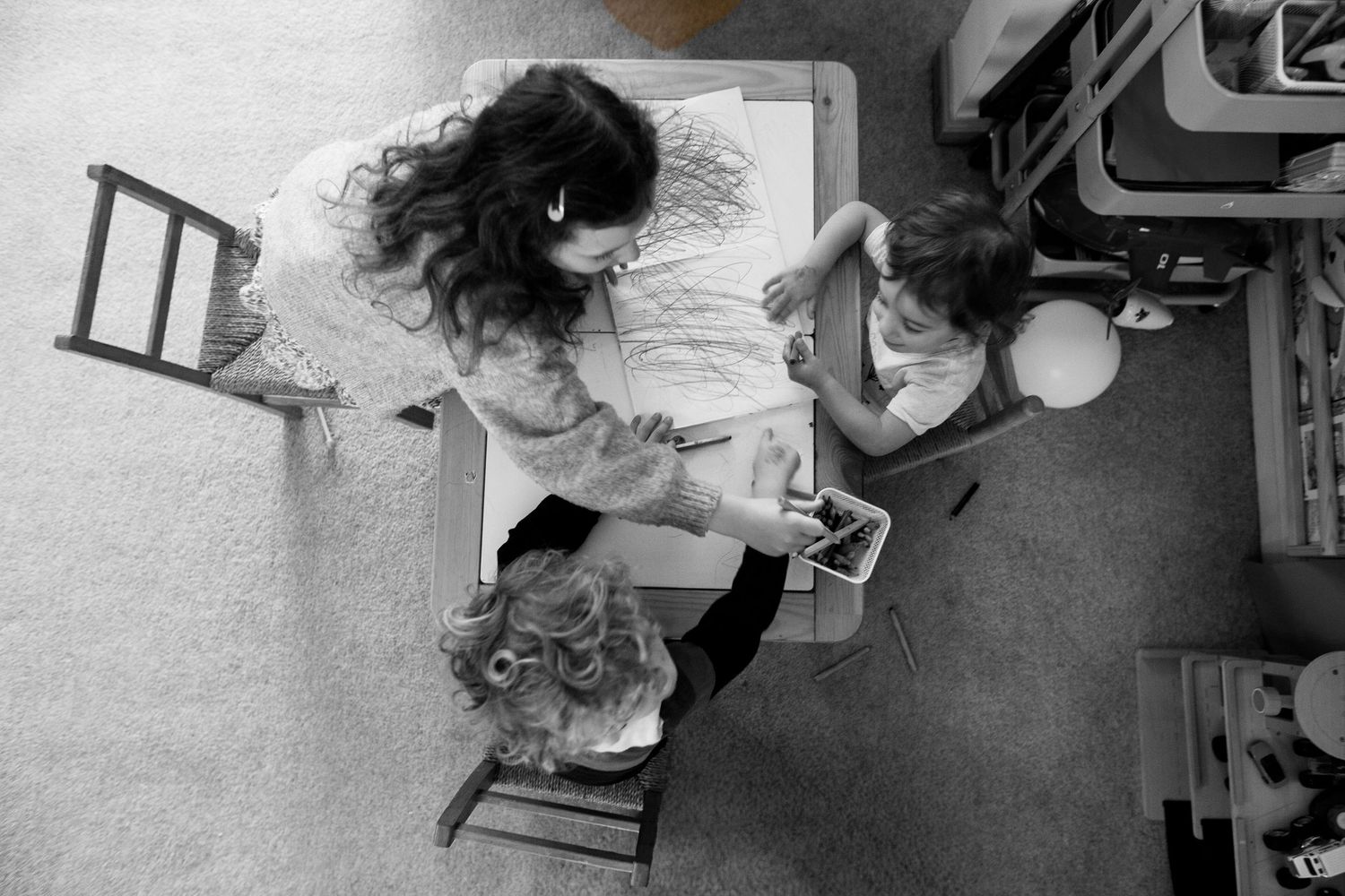 3 kids drawing during a candid and fun documentary family and childhood photoshoot by The Mother's Eye in Beckenham, South East London.