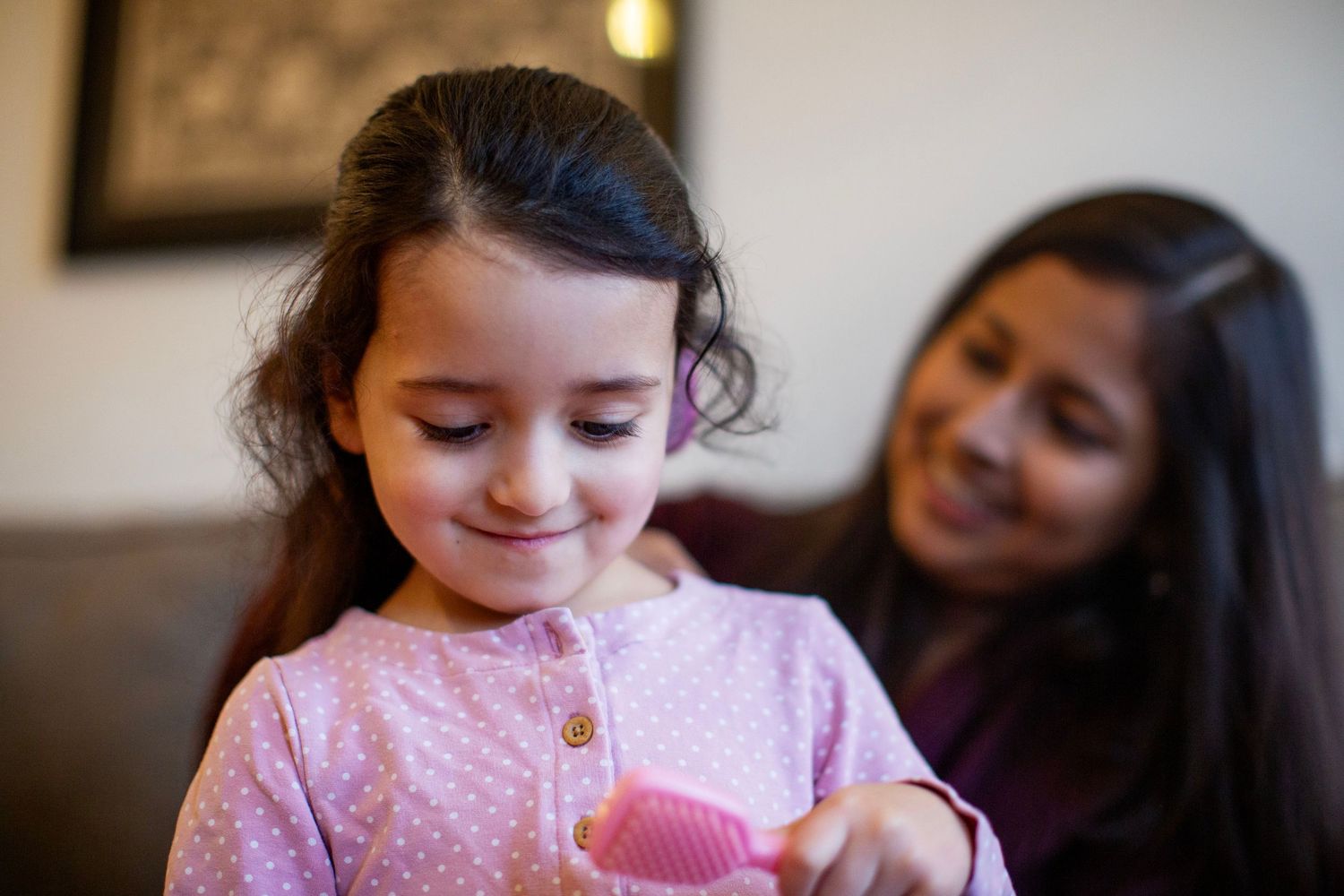 Mum and a 3 year old toddler brushing hair.Childhood and motherhood photography by The Mother's Eye in Beckenham and South East London.