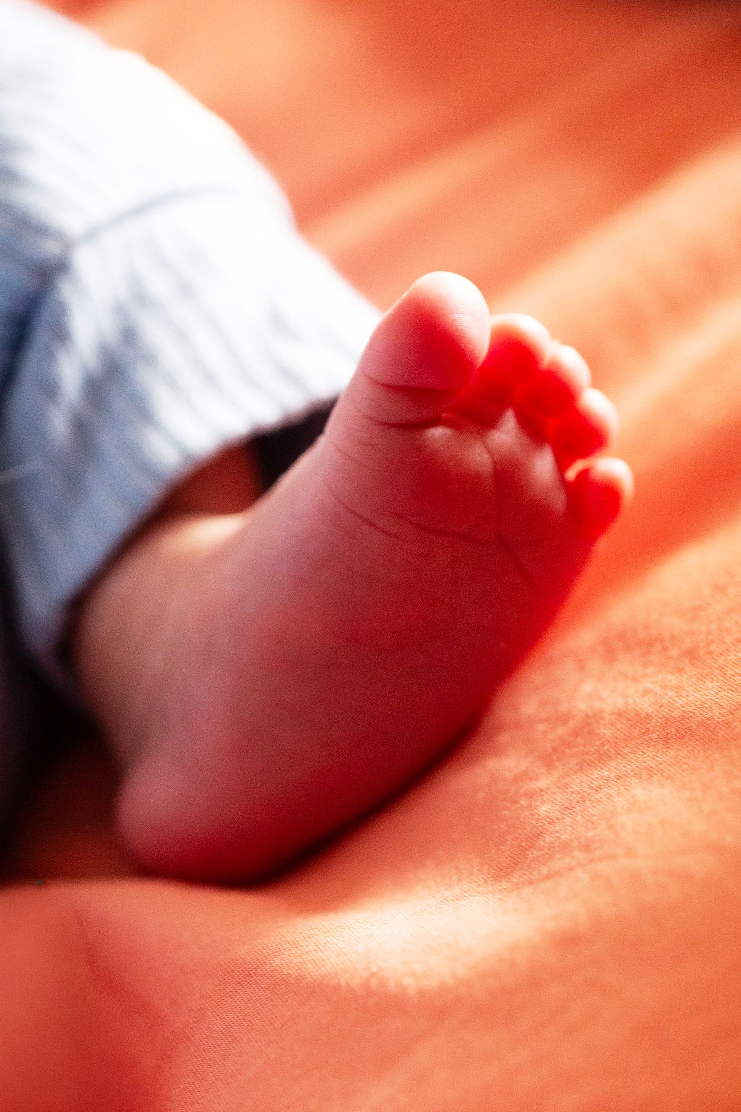 Close up of a a newborn's foot on a bed. Newborn, Postpartum and Fourth Trimester photography by The Mother's Eye, Norwood, London.