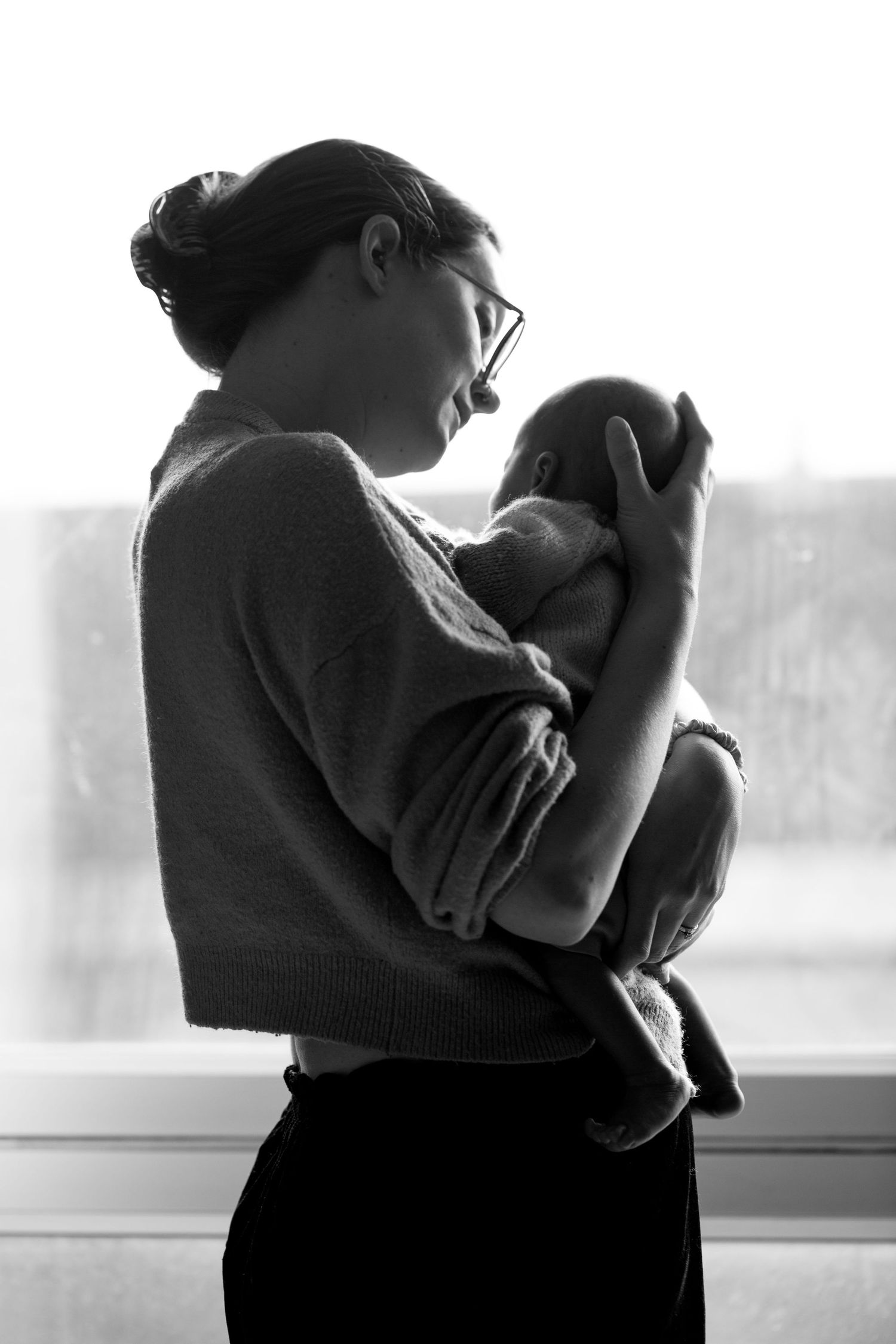 Mum and newborn by the window. Newborn, matrescence, postpartum and Fourth Trimester photography by The Mother's Eye in Bromley, London.