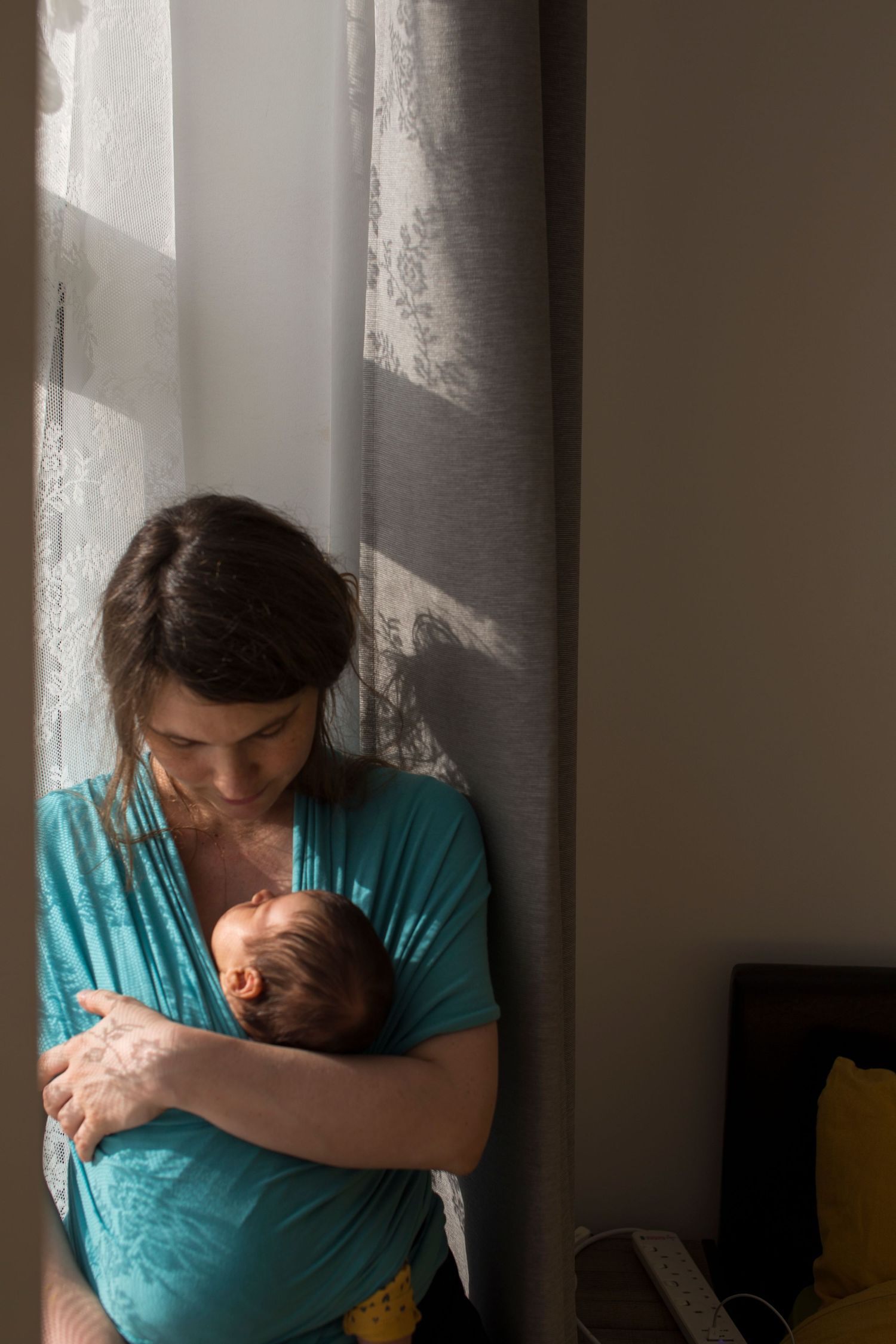 Self-portrait of The Mother's Eye photographer with her baby in a sling. Motherhood photography East Dulwich, South East London.