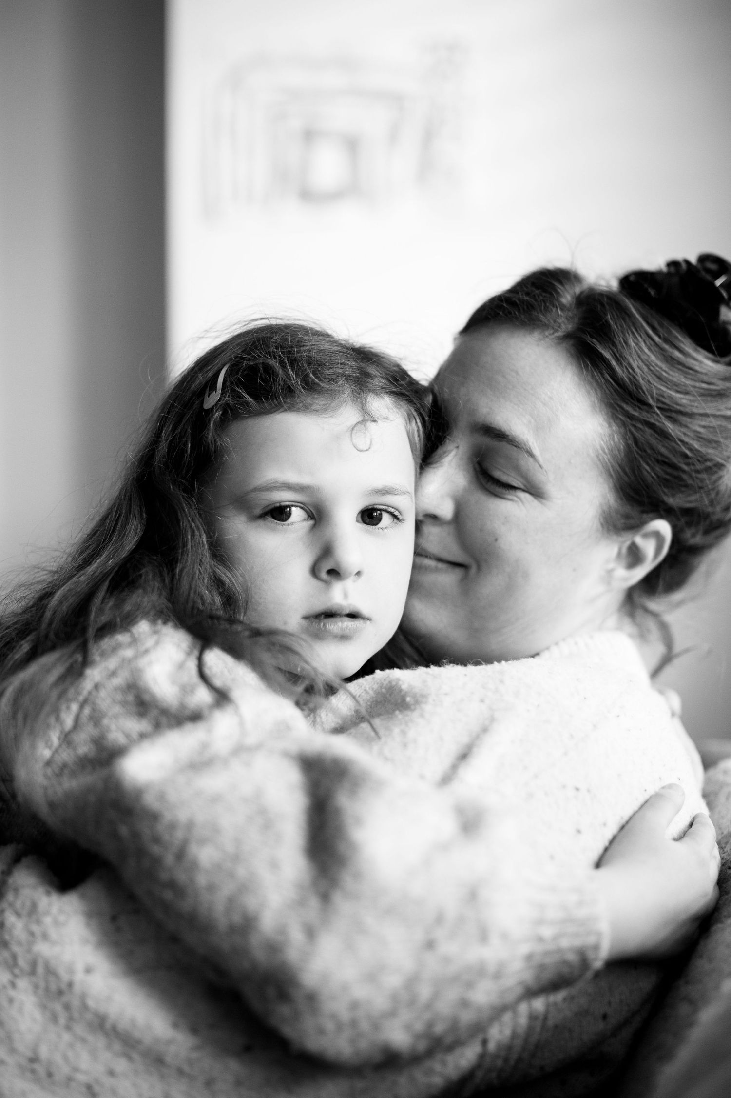 Mum and daughter cuddle at a photo session. The Mother's Eye - candid documentary-stele motherhood photography in Crystal Palace, SE London.