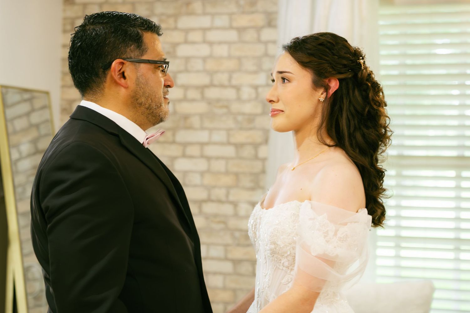 Bride and groom share an intimate moment in elegant wedding attire at a bright, modern venue.