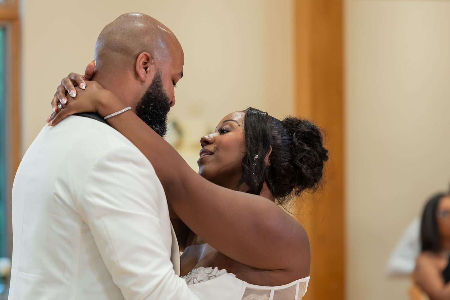 A bride and groom share an intimate first dance, gazing lovingly at each other during their wedding reception.