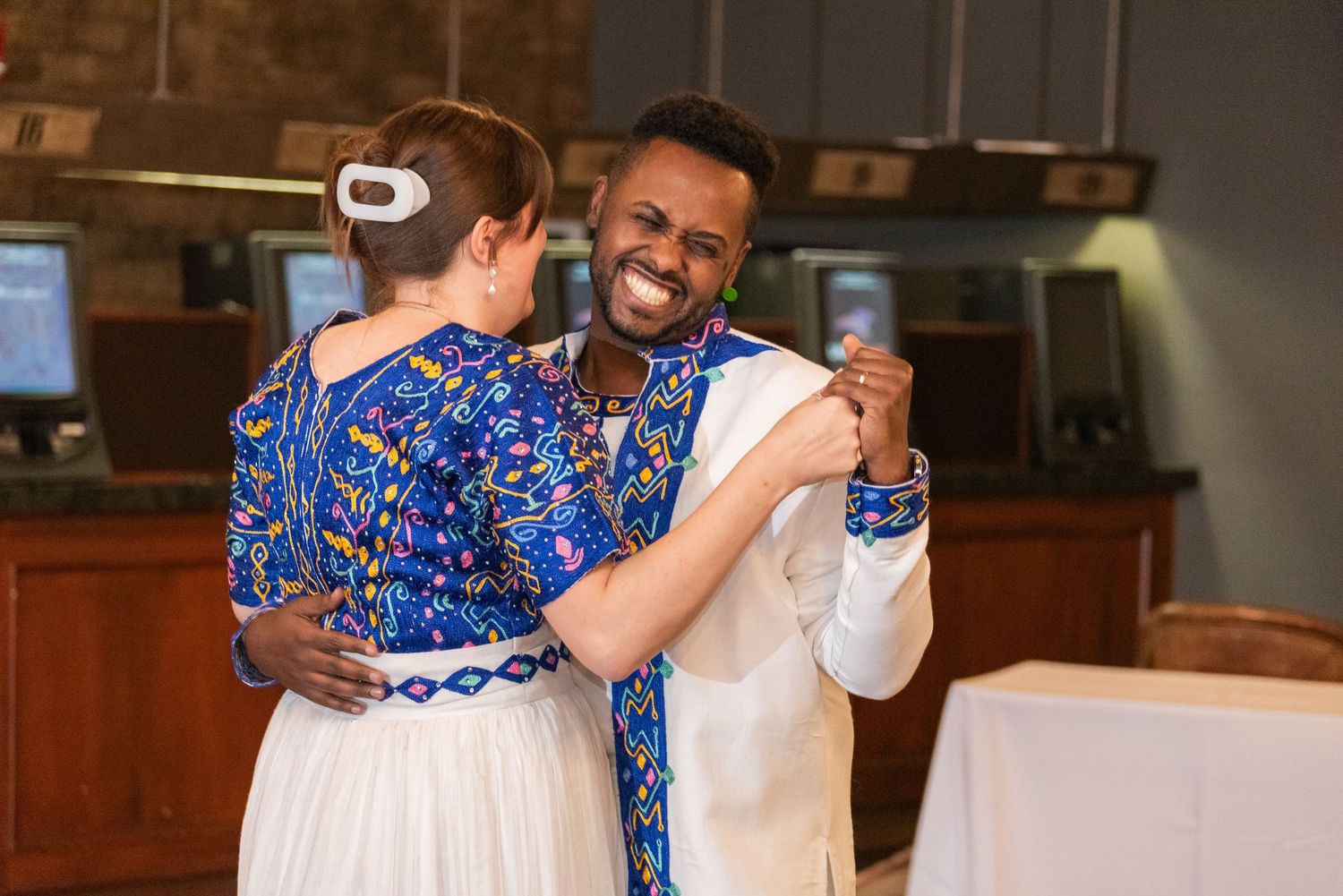 Couple sharing first dance in traditional Ethiopian wedding attire at reception venue.