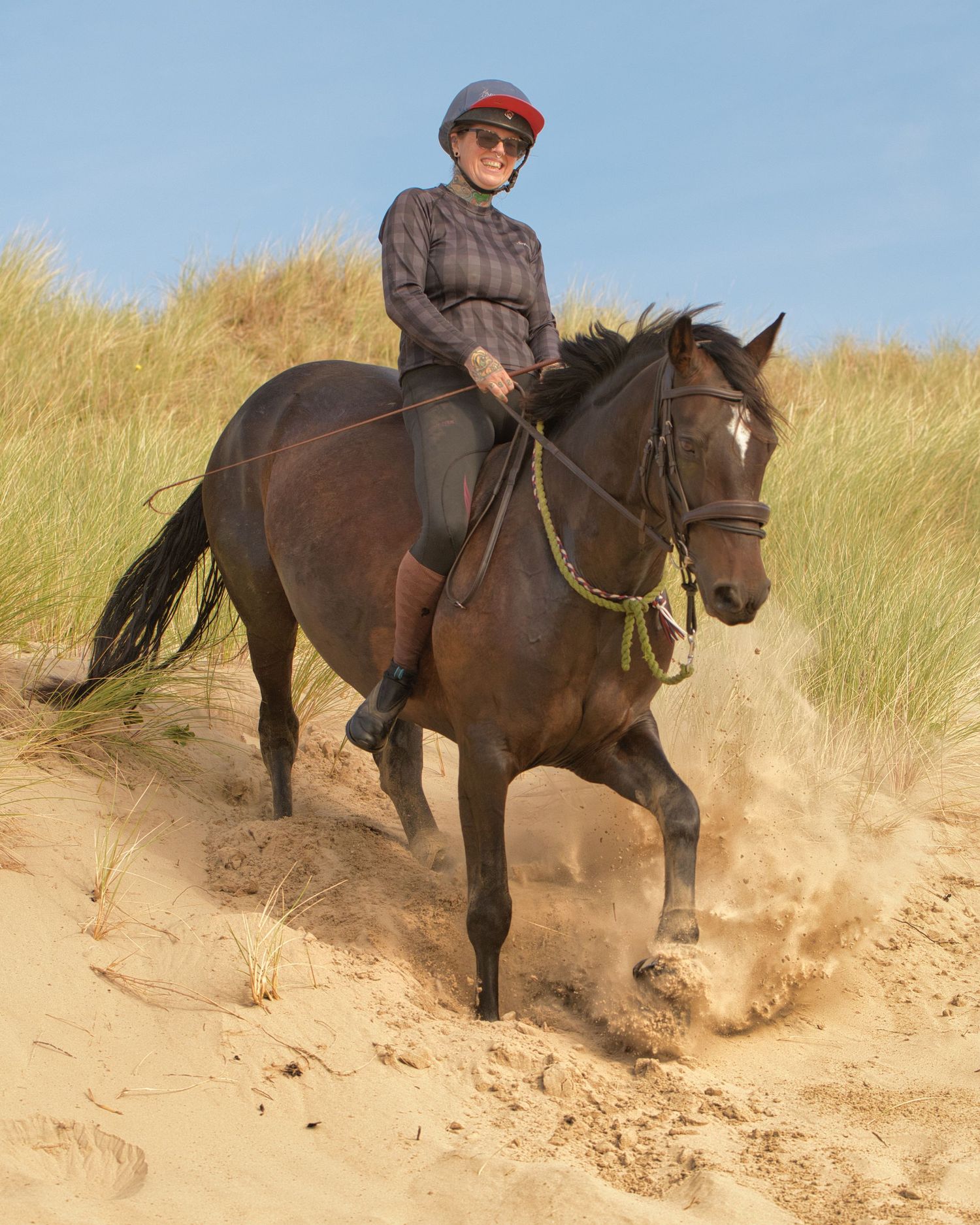 Horse ridden bareback over sandy dunes, rider enjoying the ride with natural movement captured in an outdoor equine photography session